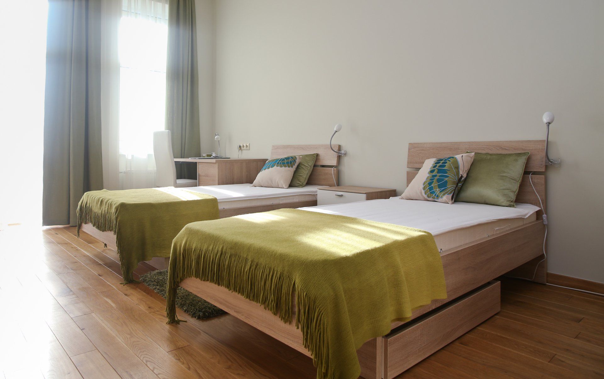 A bedroom with two beds and a window.