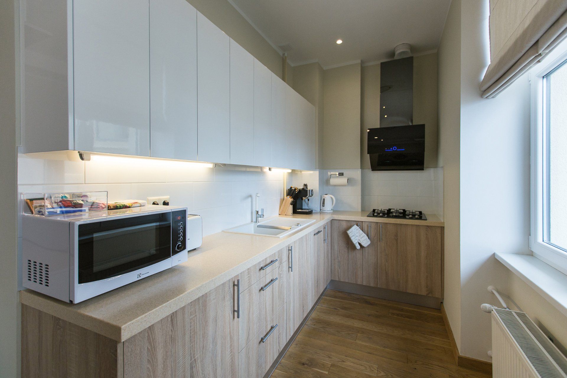 A kitchen with a microwave , sink , stove and window.