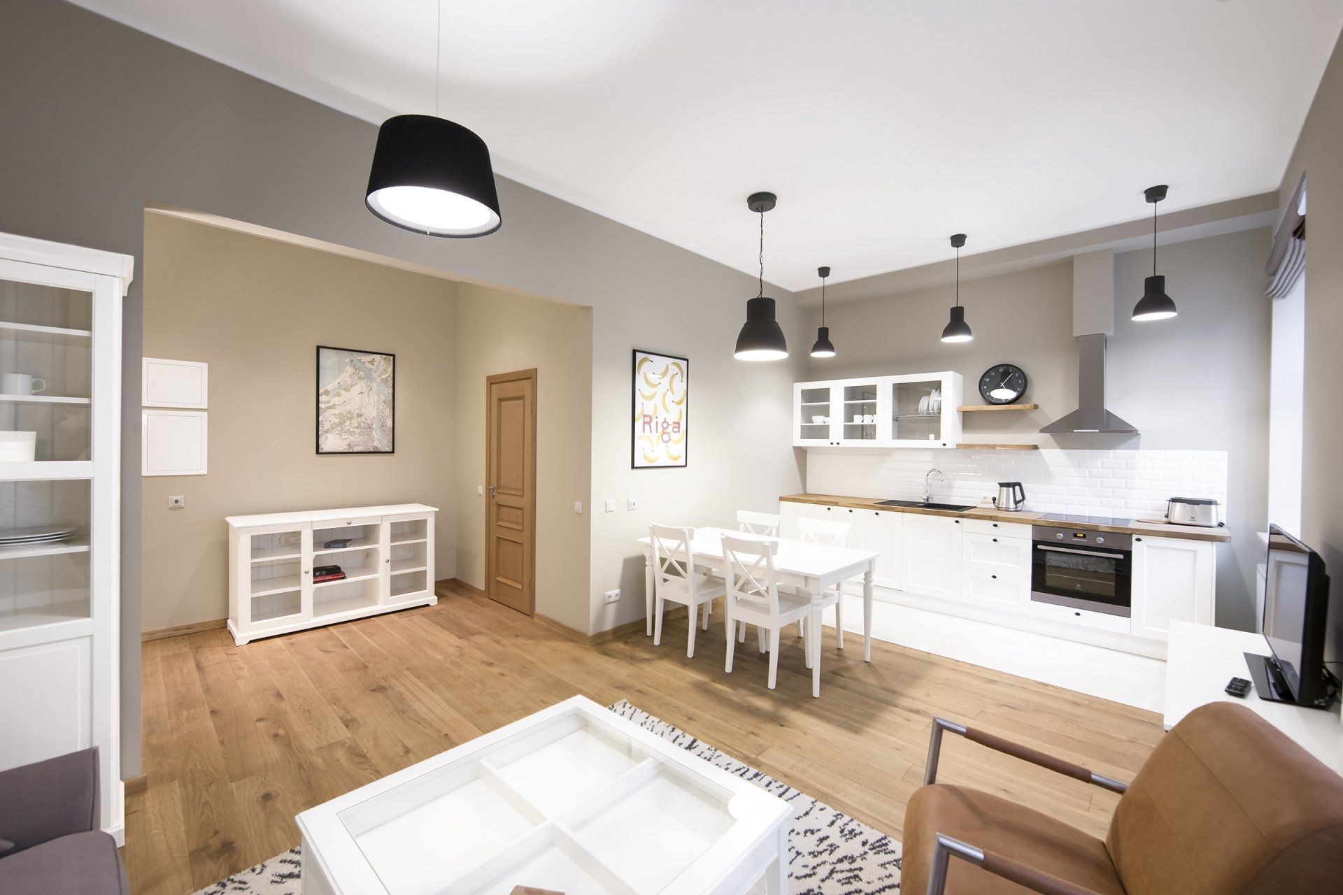 A living room with a table and chairs and a kitchen.