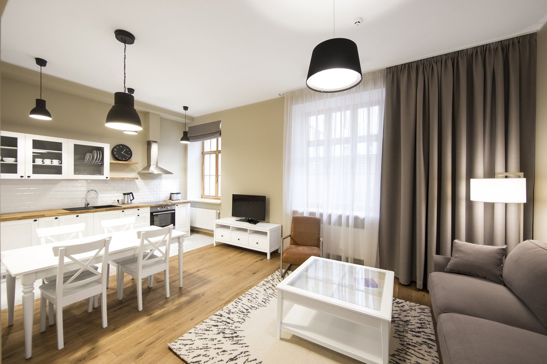 A living room with a couch , table , chairs and a television.