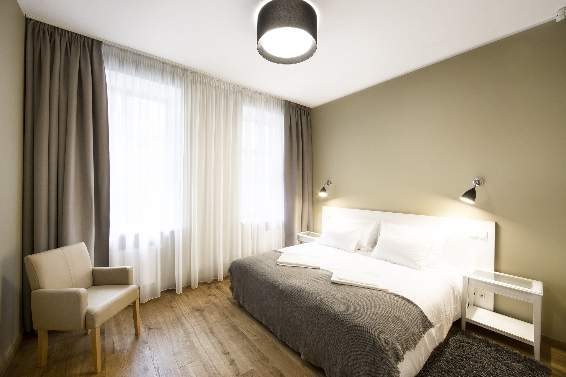 A bedroom with a large bed and a chair