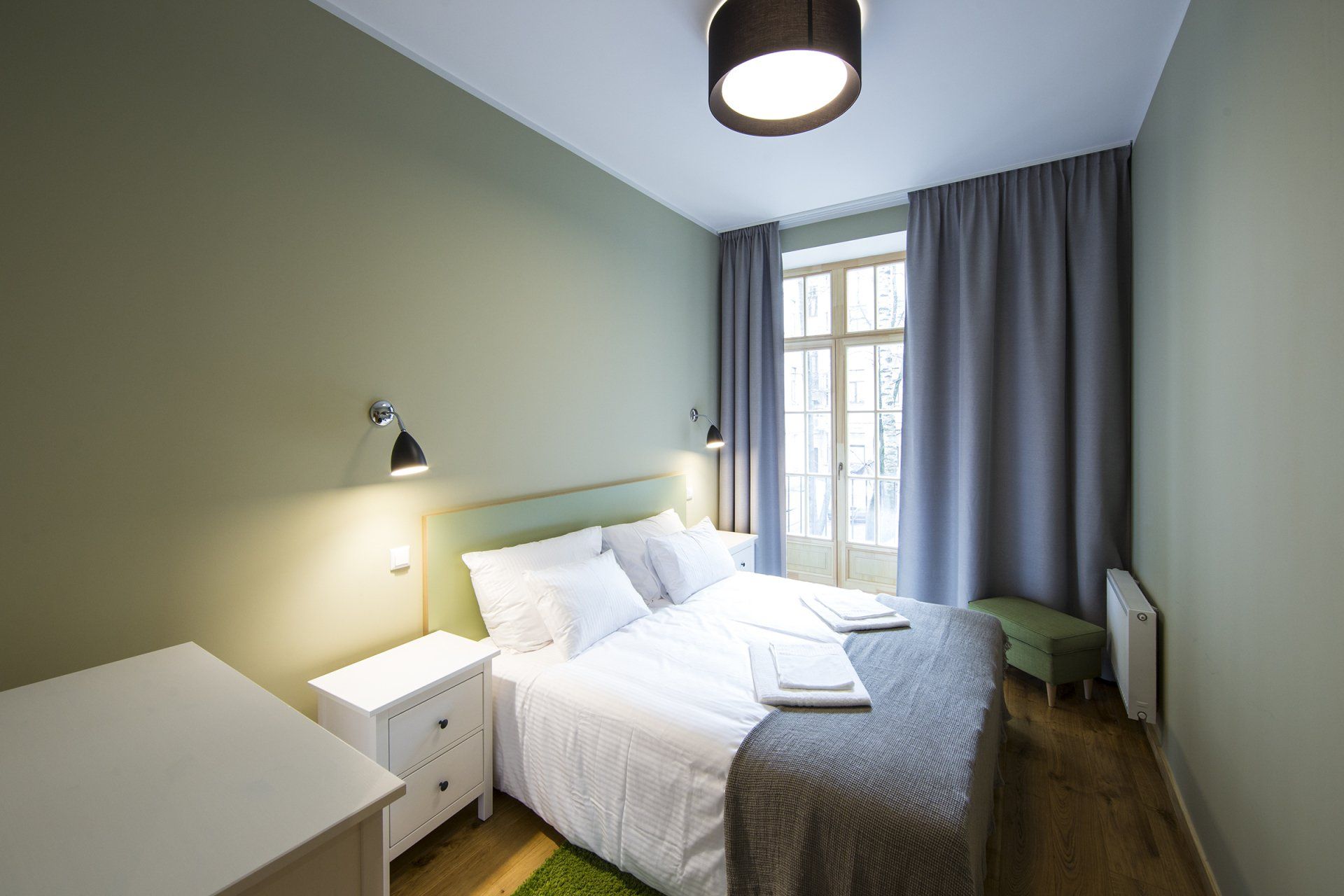 A bedroom with a bed , nightstand , and window.