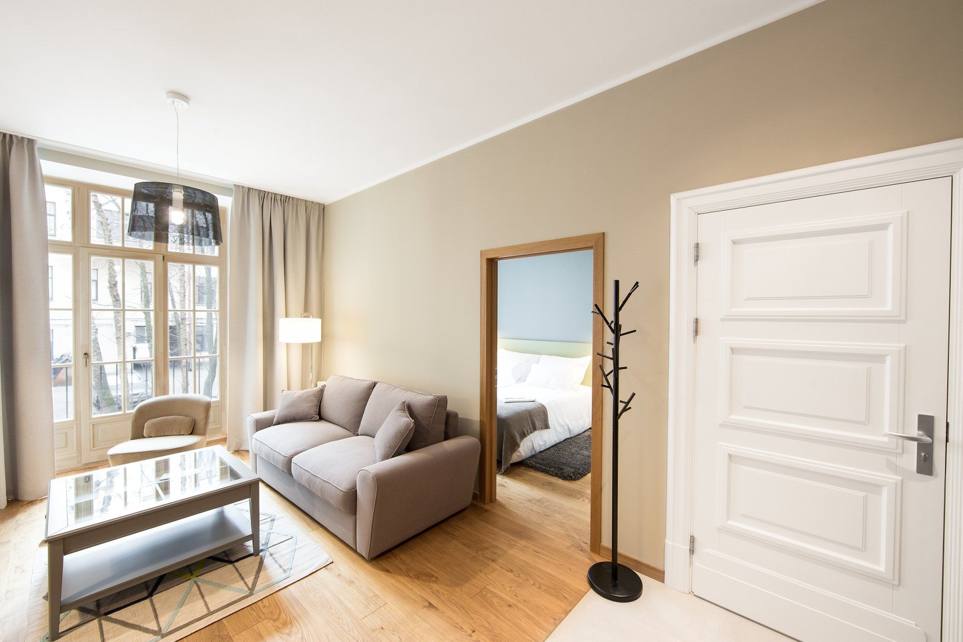 A living room with a couch , coffee table , and doorway leading to a bedroom.