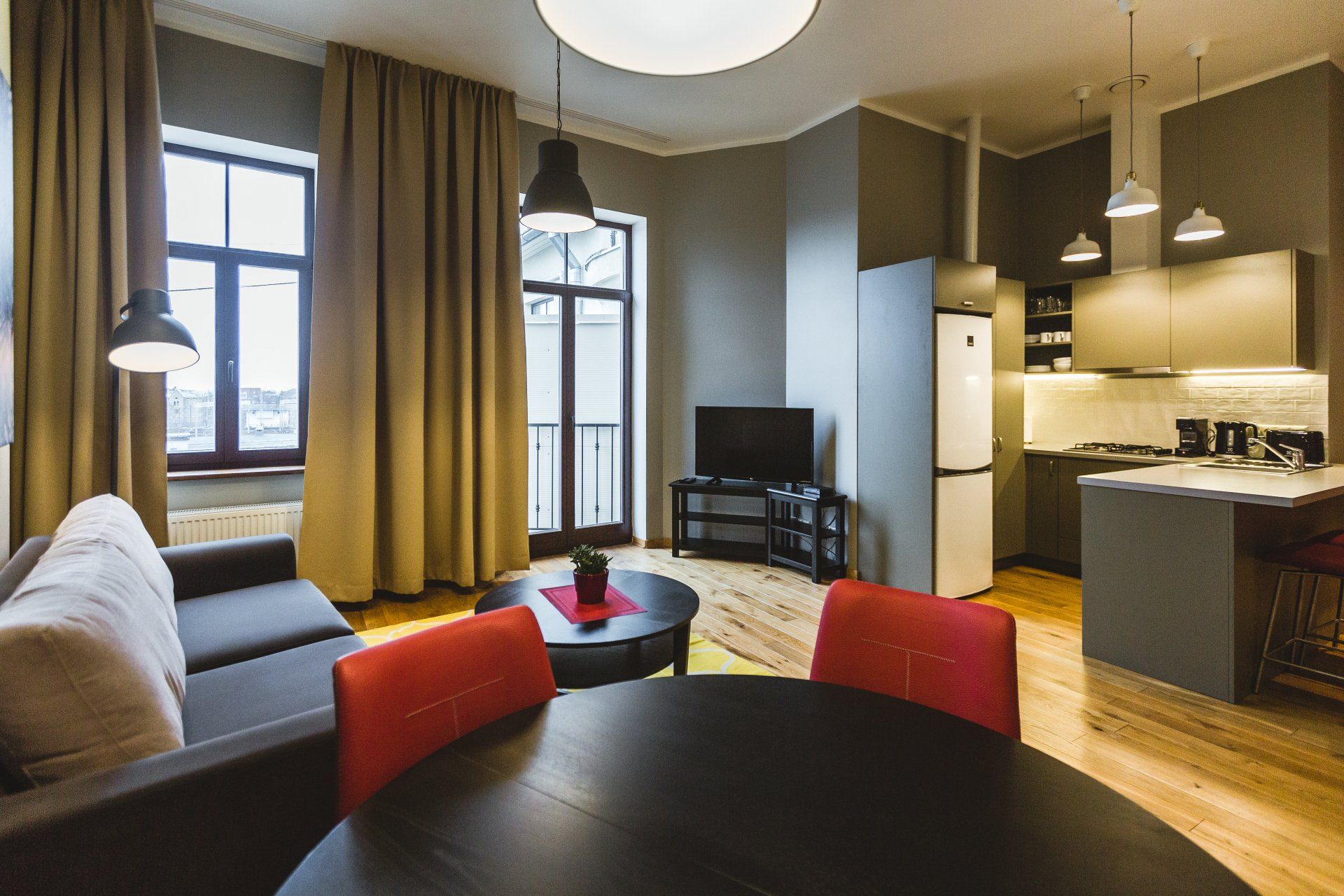 A living room with a couch , table , chairs and a television.