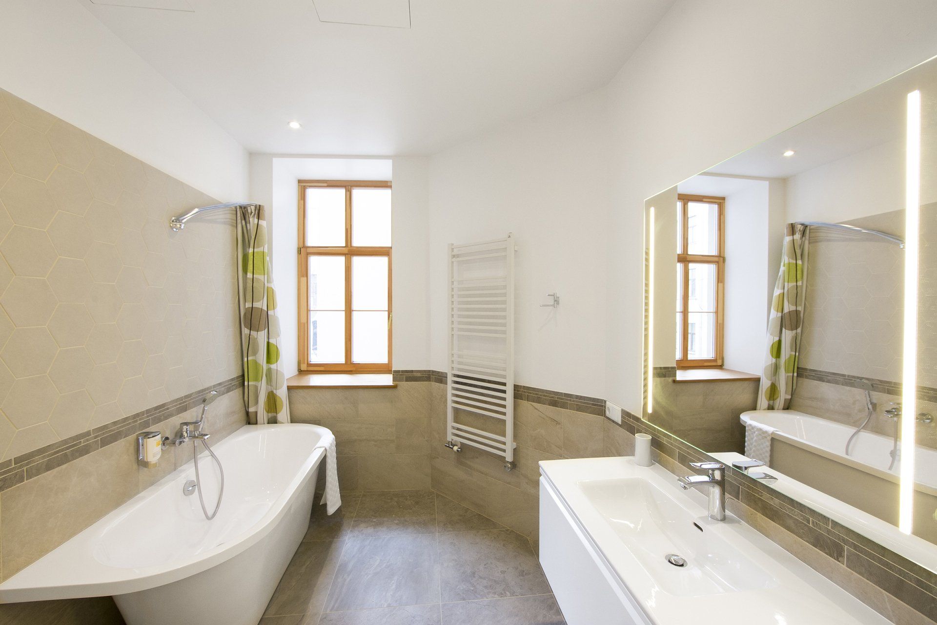 A bathroom with a tub , sink , and mirror.