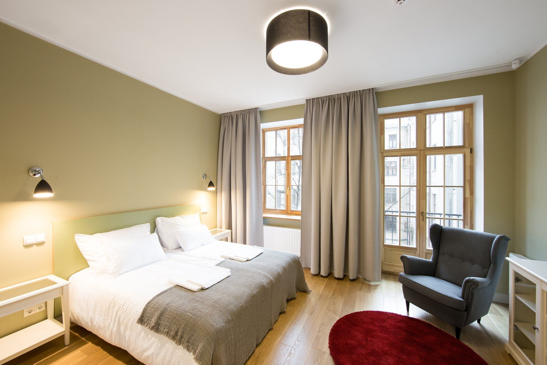 A bedroom with a bed , chair and window.