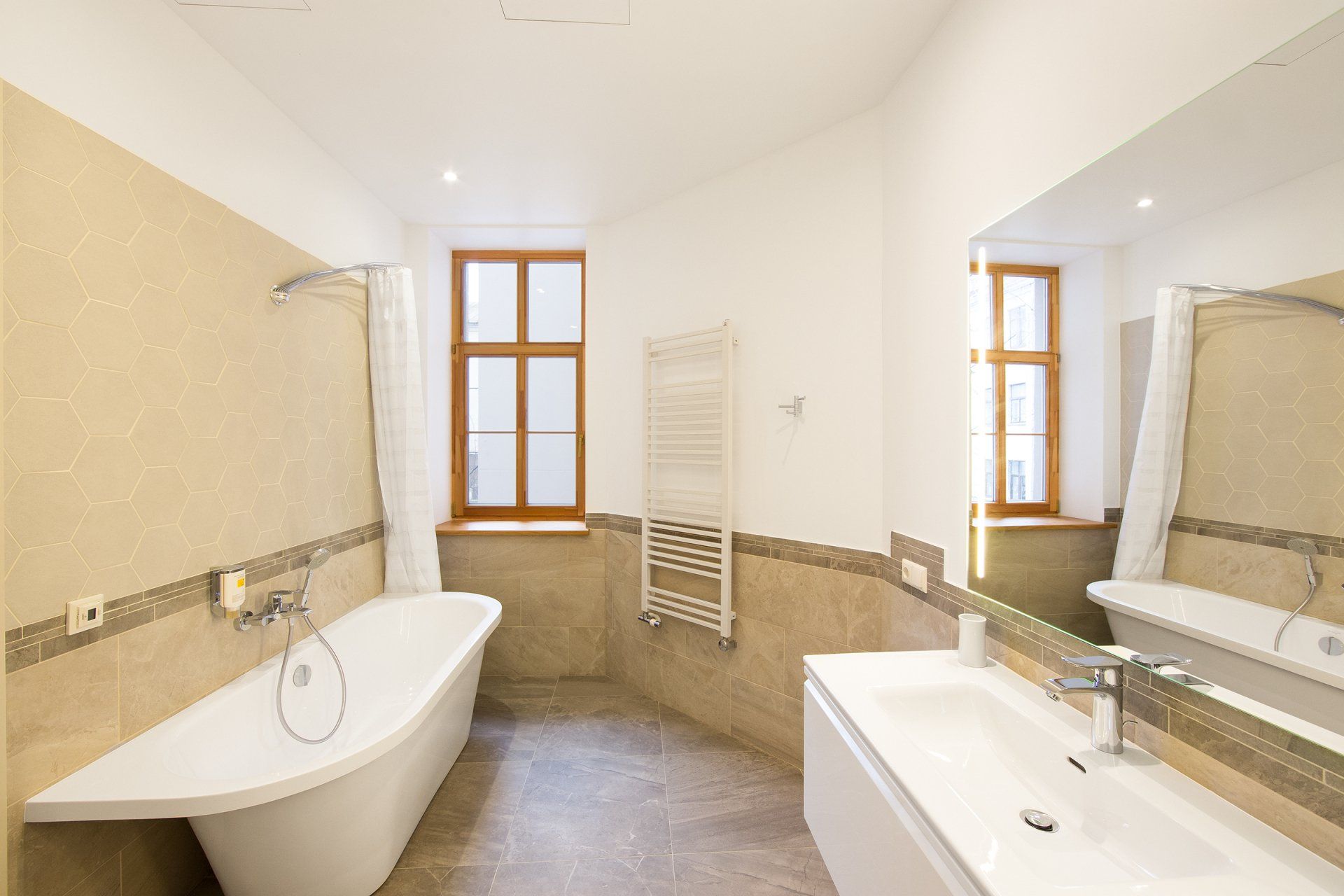 A bathroom with a tub , sink , and mirror.