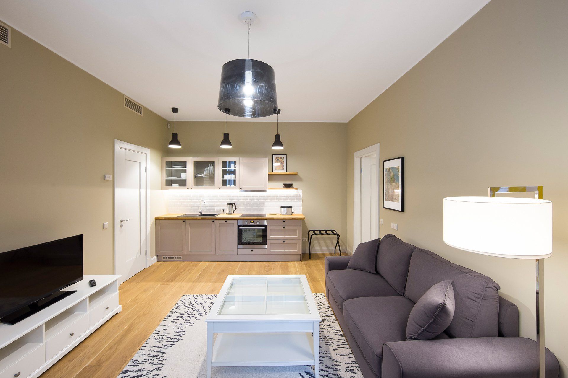 A living room with a purple couch and a white coffee table