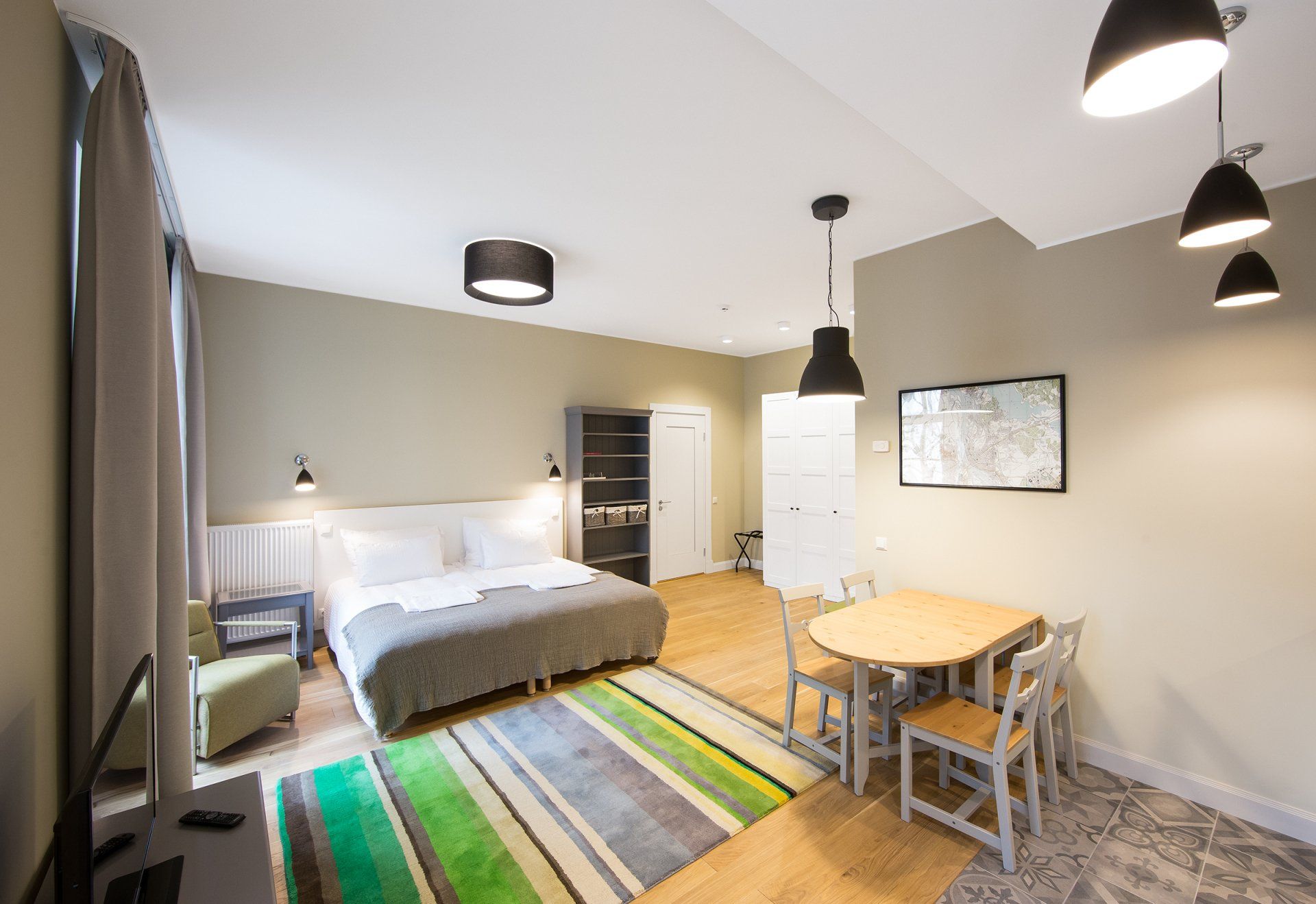 A hotel room with a bed , table and chairs.