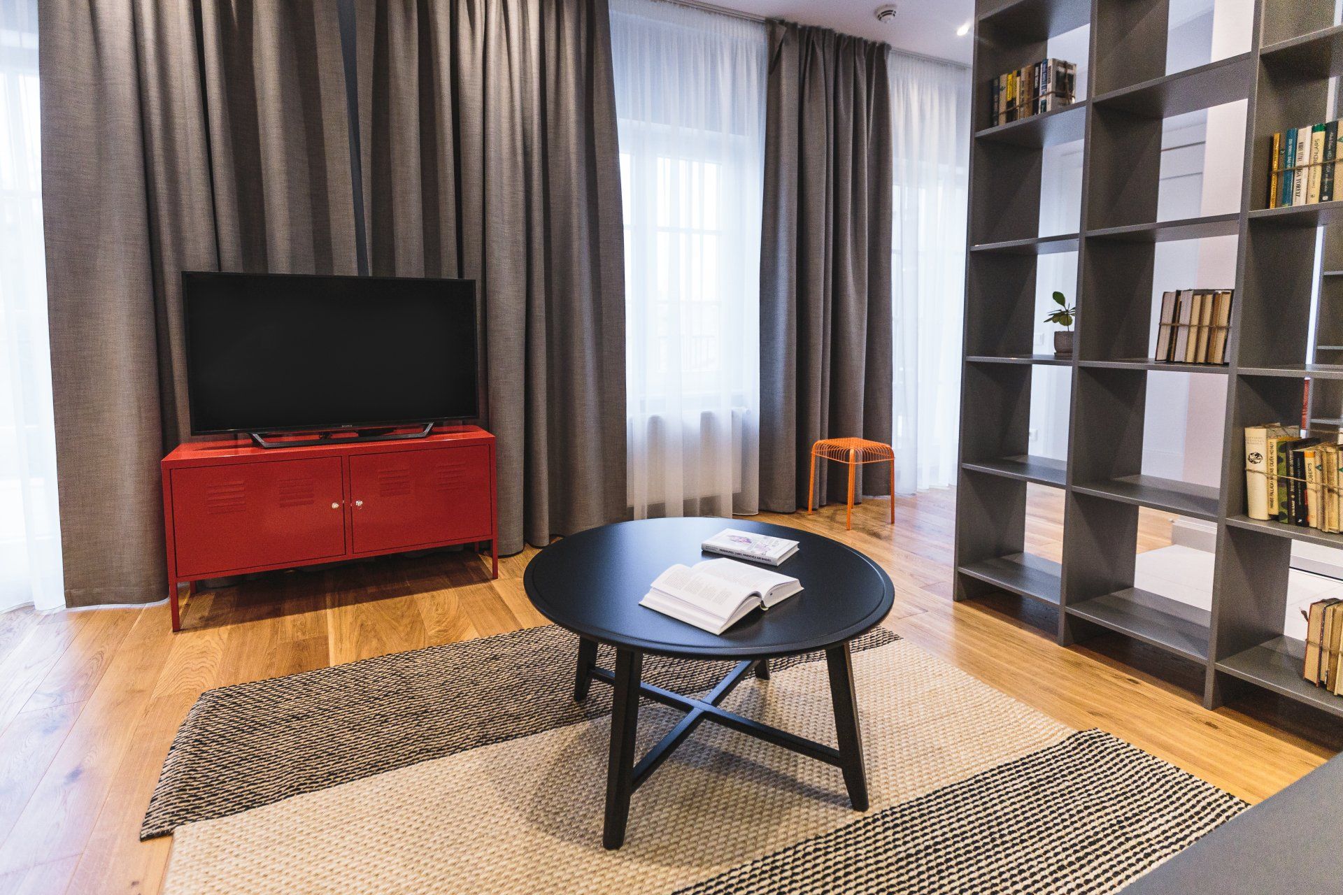 A living room with a round coffee table and a flat screen tv.