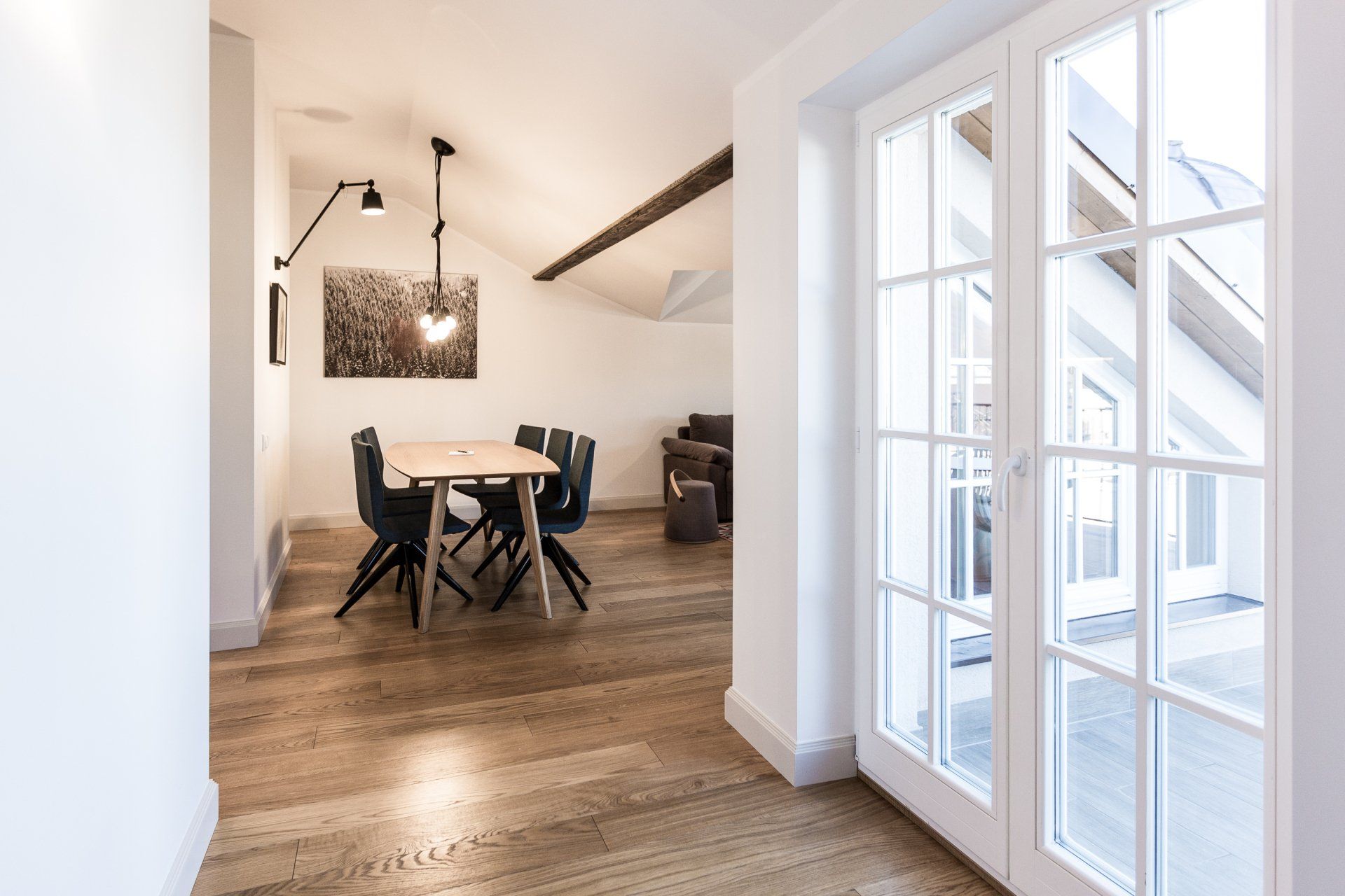 A dining room with a table and chairs and a sliding glass door.