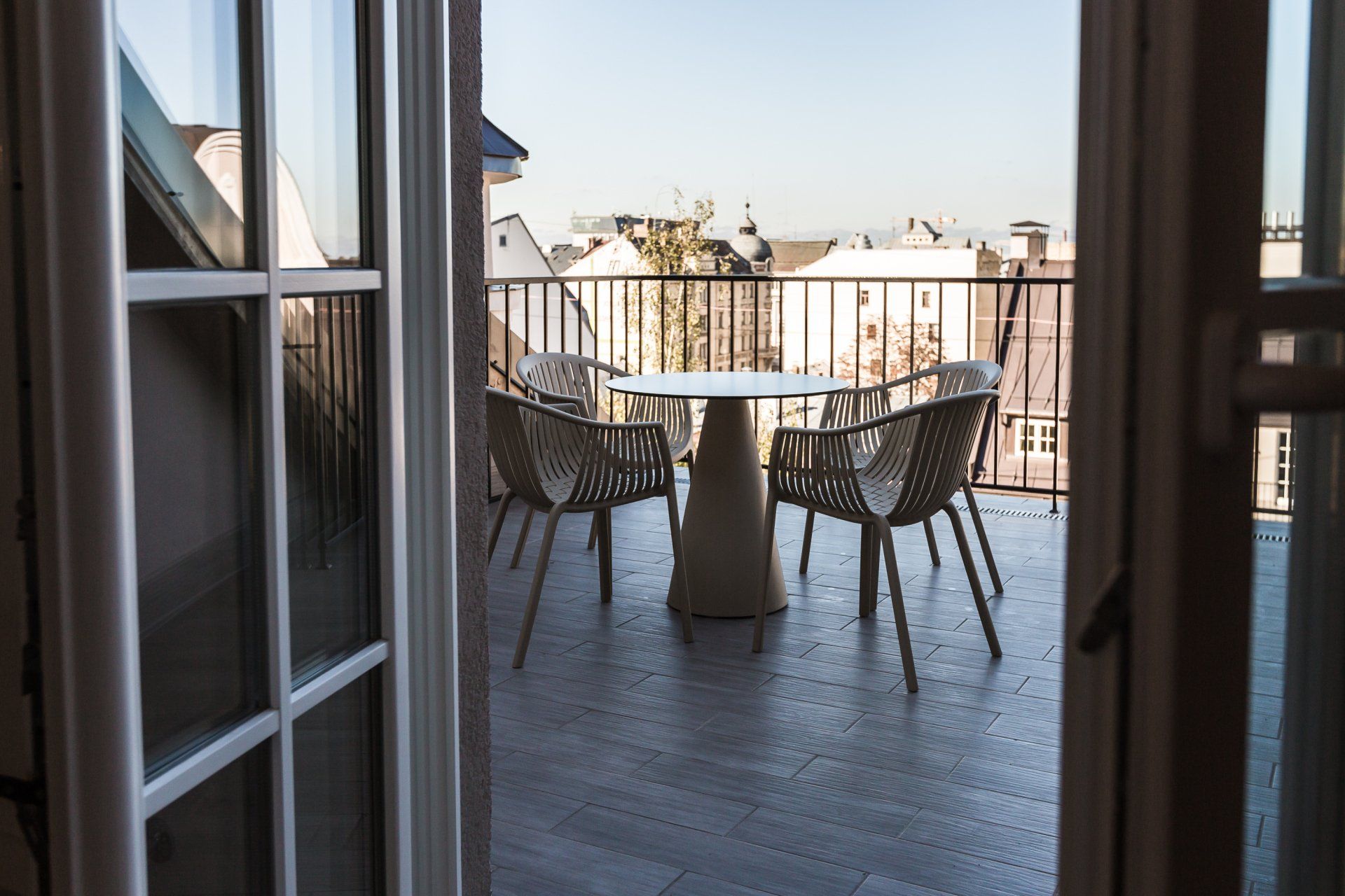 A balcony with a table and chairs and a view of a city.