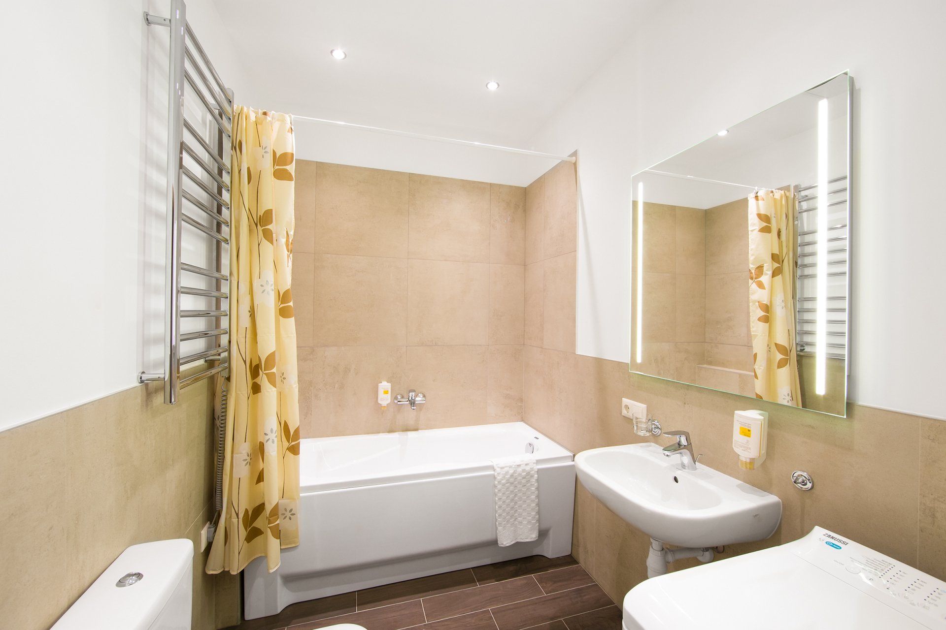 A bathroom with a bathtub , sink , toilet and mirror.