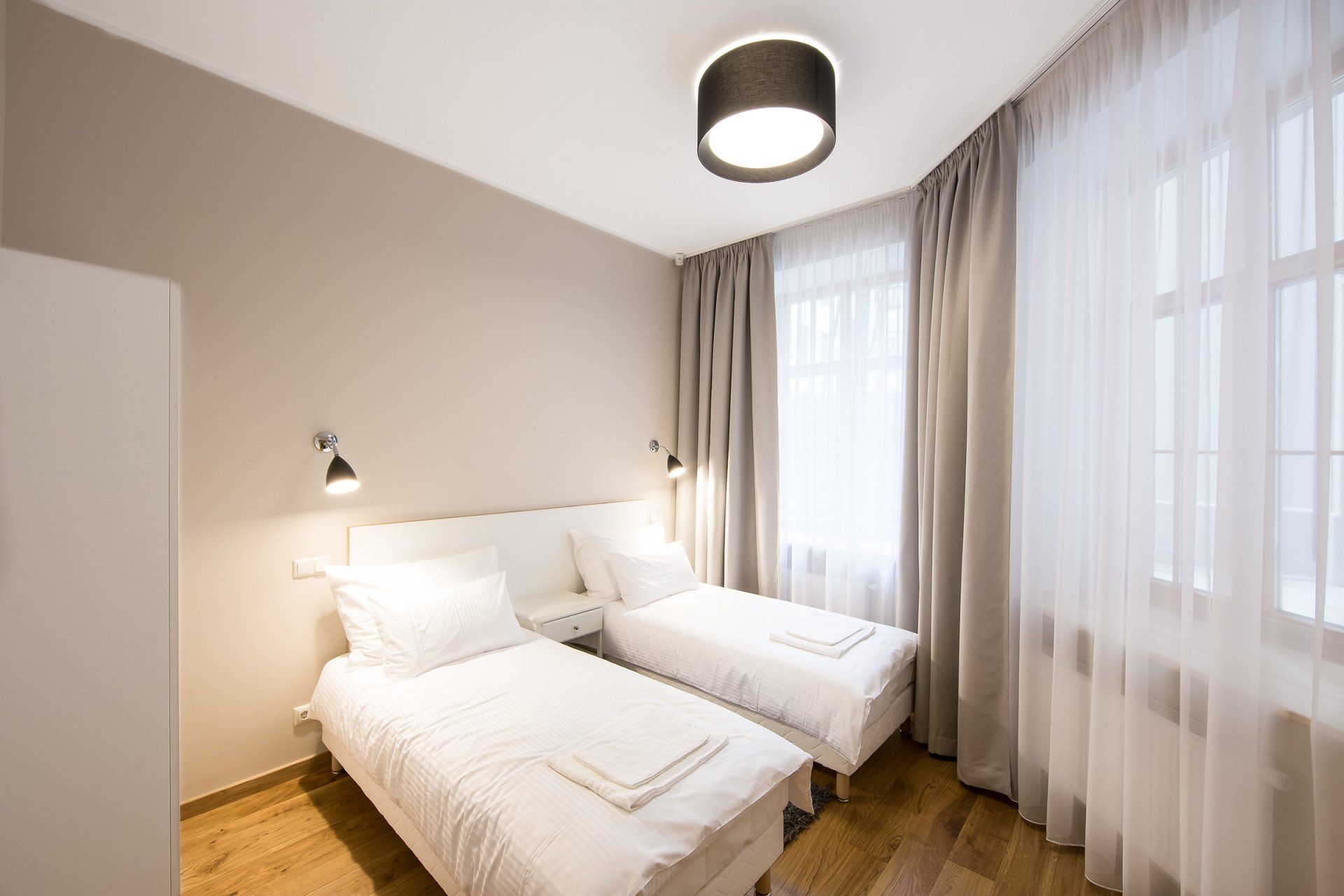 A hotel room with two beds and a window.