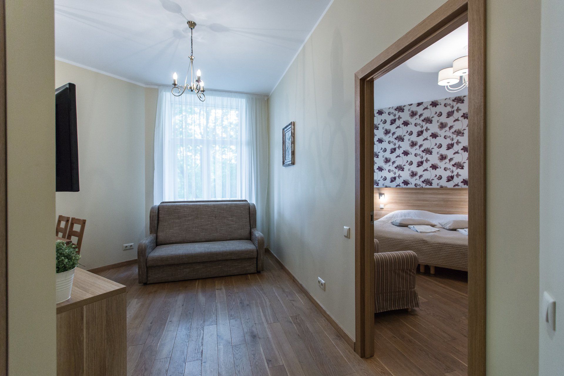 A living room with a couch and a bed in a hotel room.