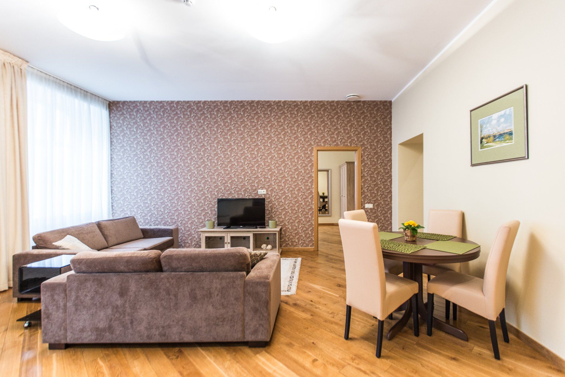 A living room with a couch , table and chairs.