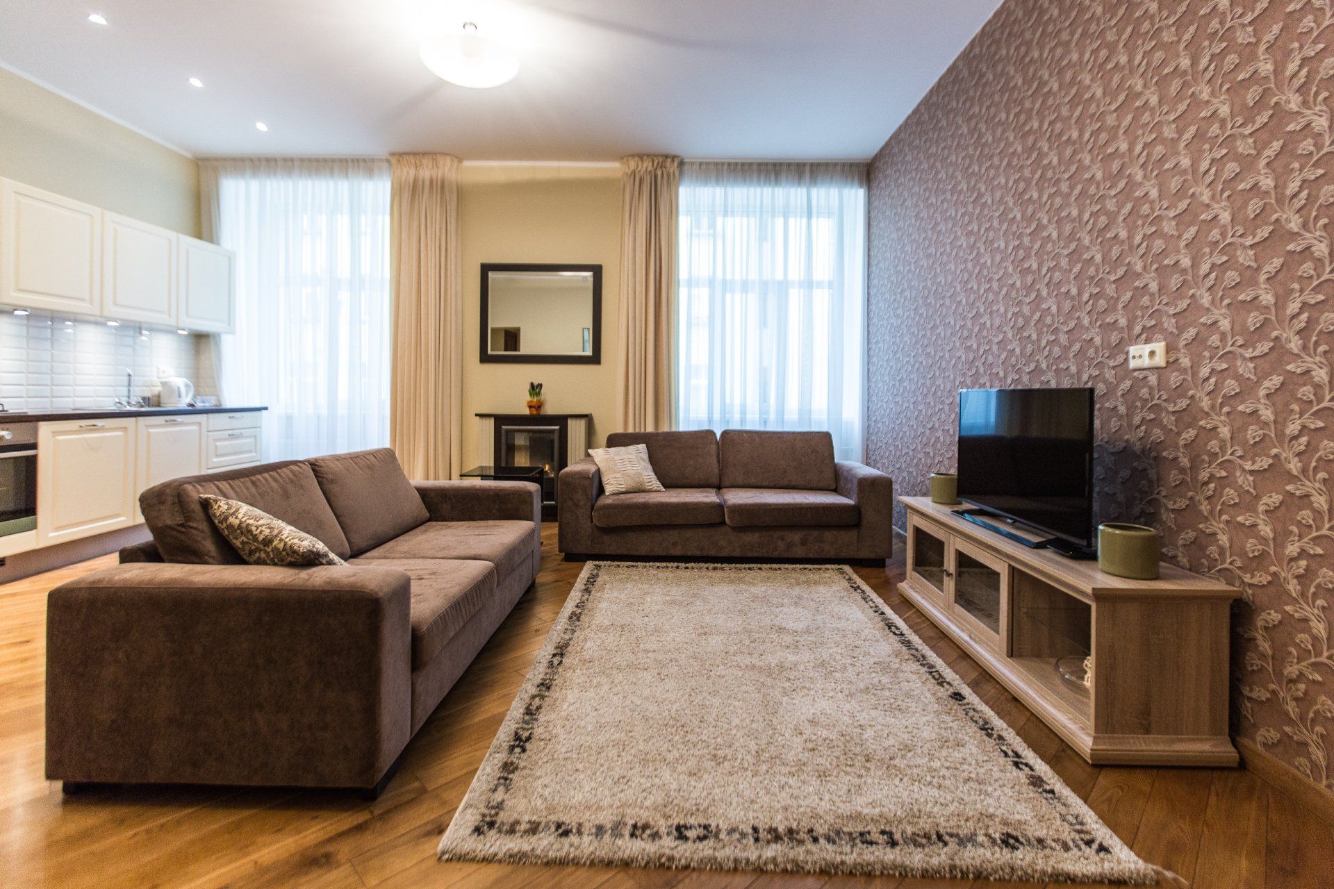 A living room with two couches and a flat screen tv.