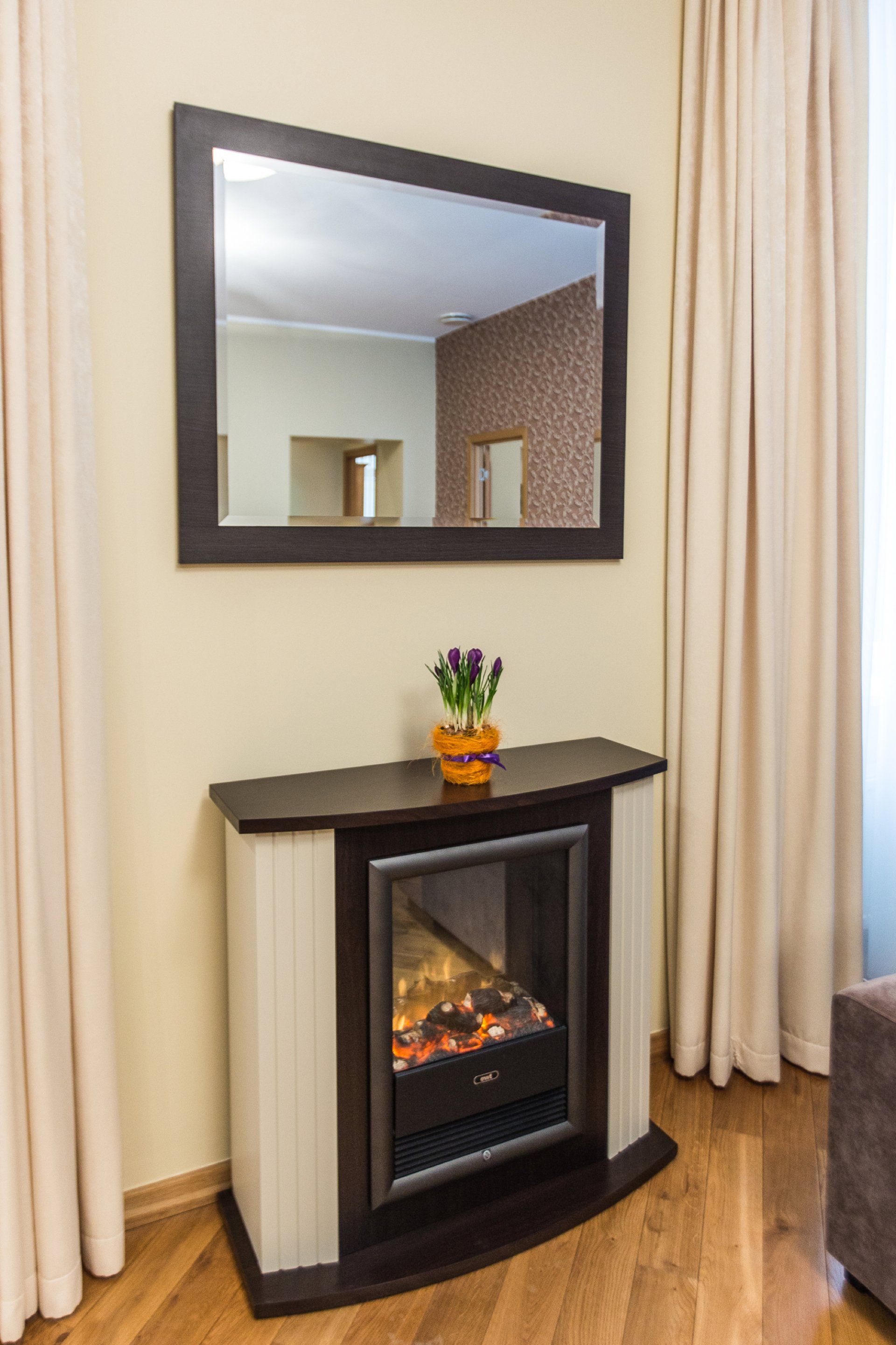 A living room with a fireplace and a mirror on the wall.