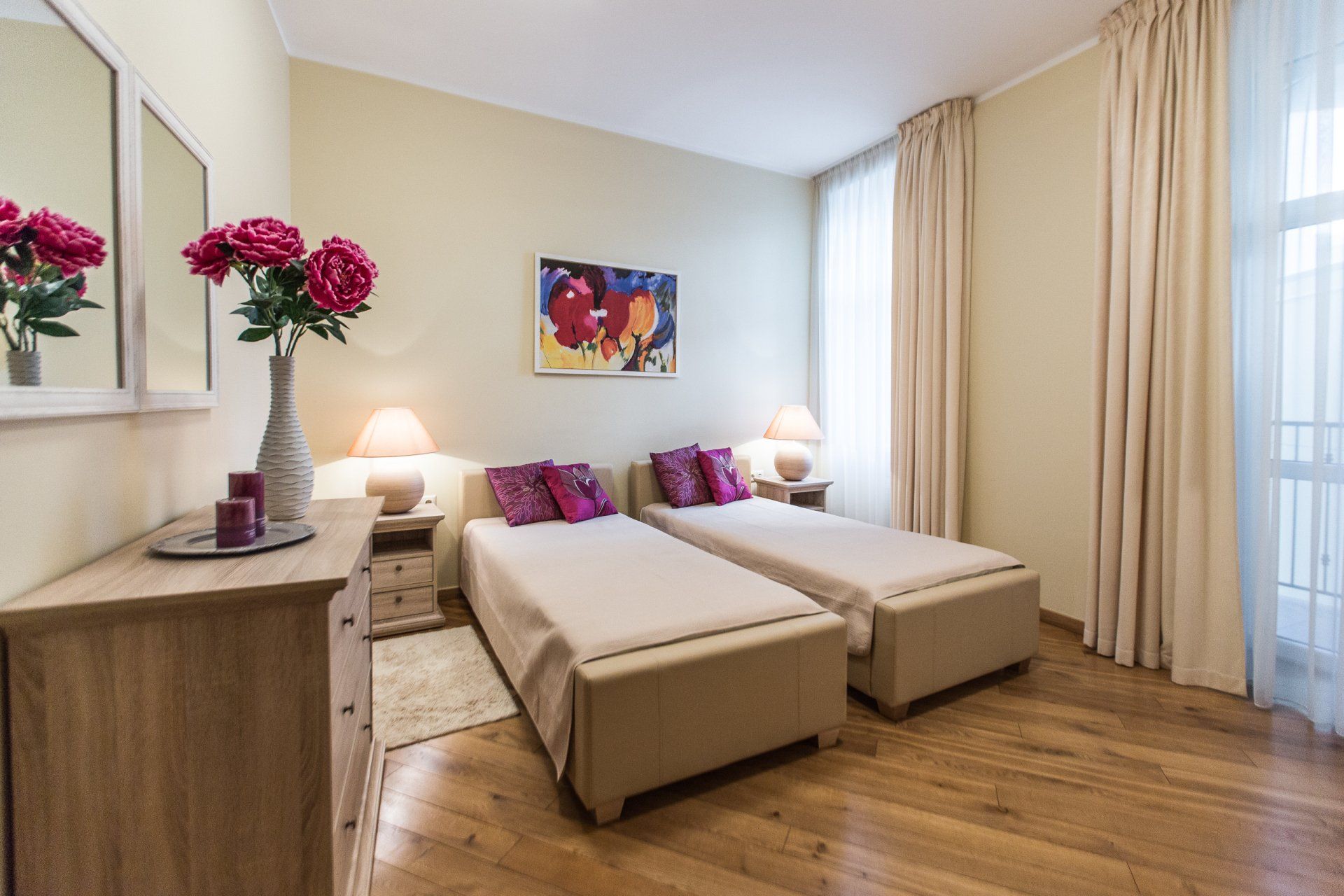 A bedroom with two beds , a dresser and a mirror.