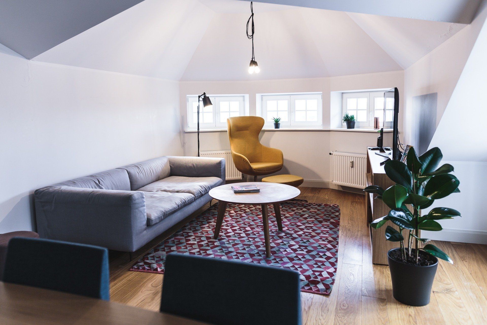 A living room with a couch , chair , table and potted plant.