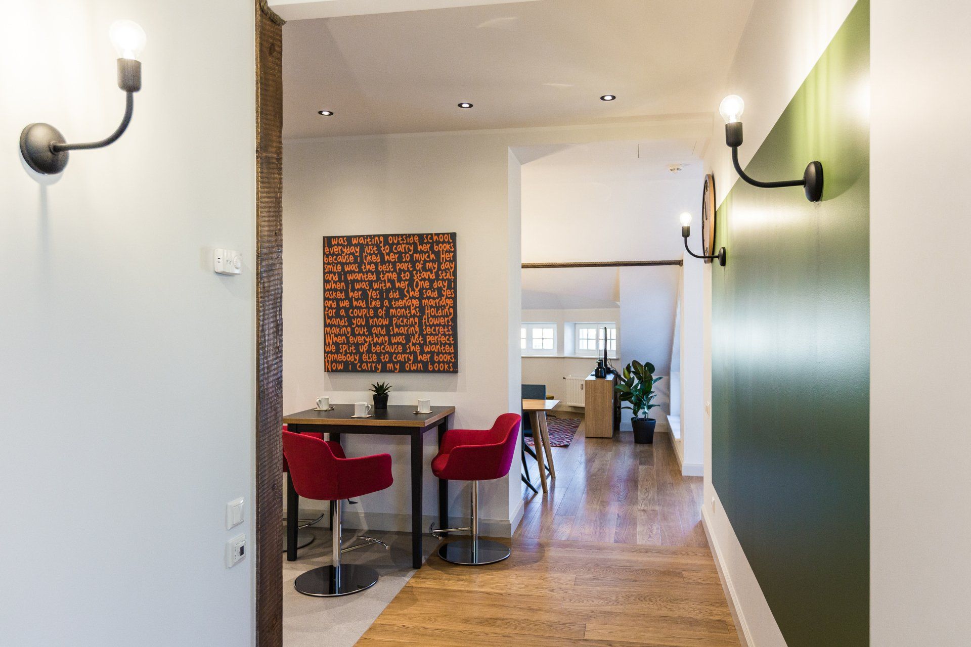 A hallway leading to a living room with a table and chairs.