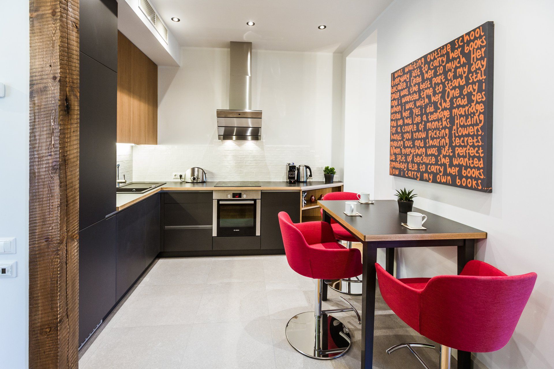 A kitchen with a table and chairs and a painting on the wall