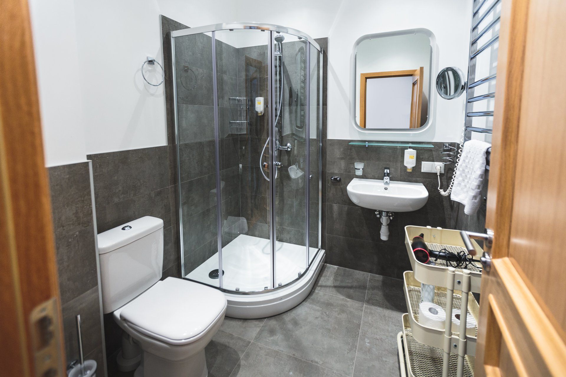 A bathroom with a toilet , sink , shower and mirror.