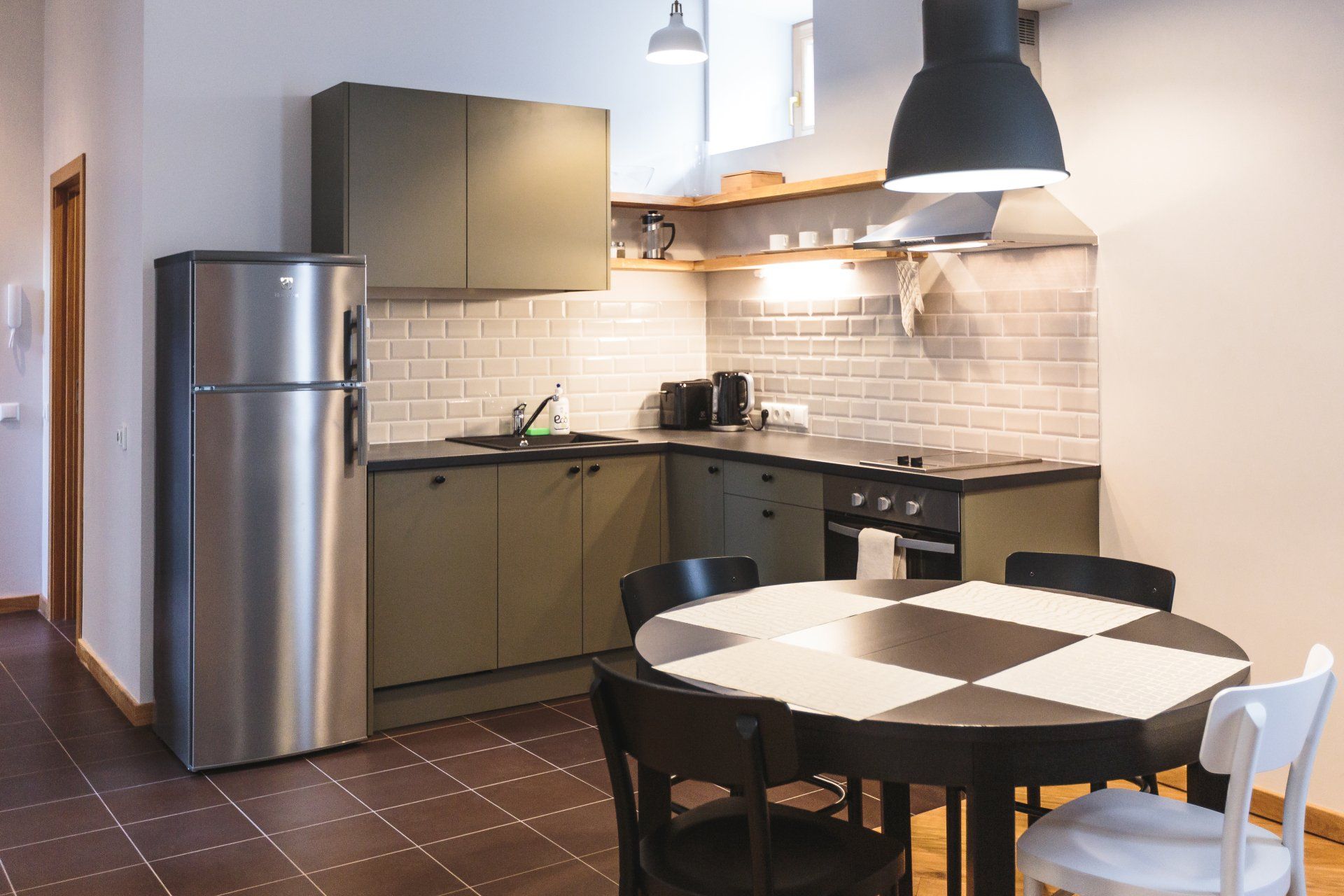 A kitchen with a table and chairs and a refrigerator