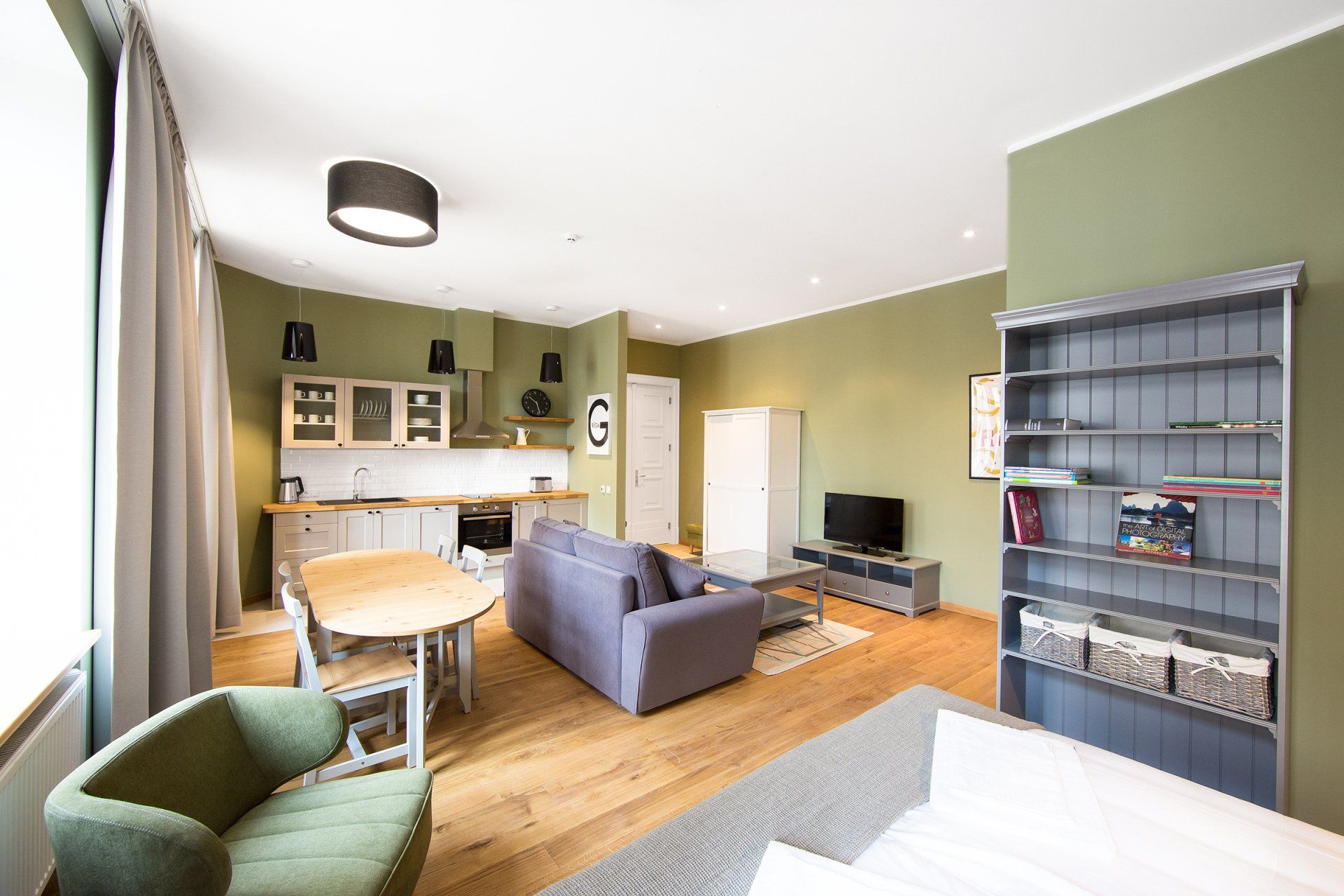 A living room with a couch , chair , table and television.
