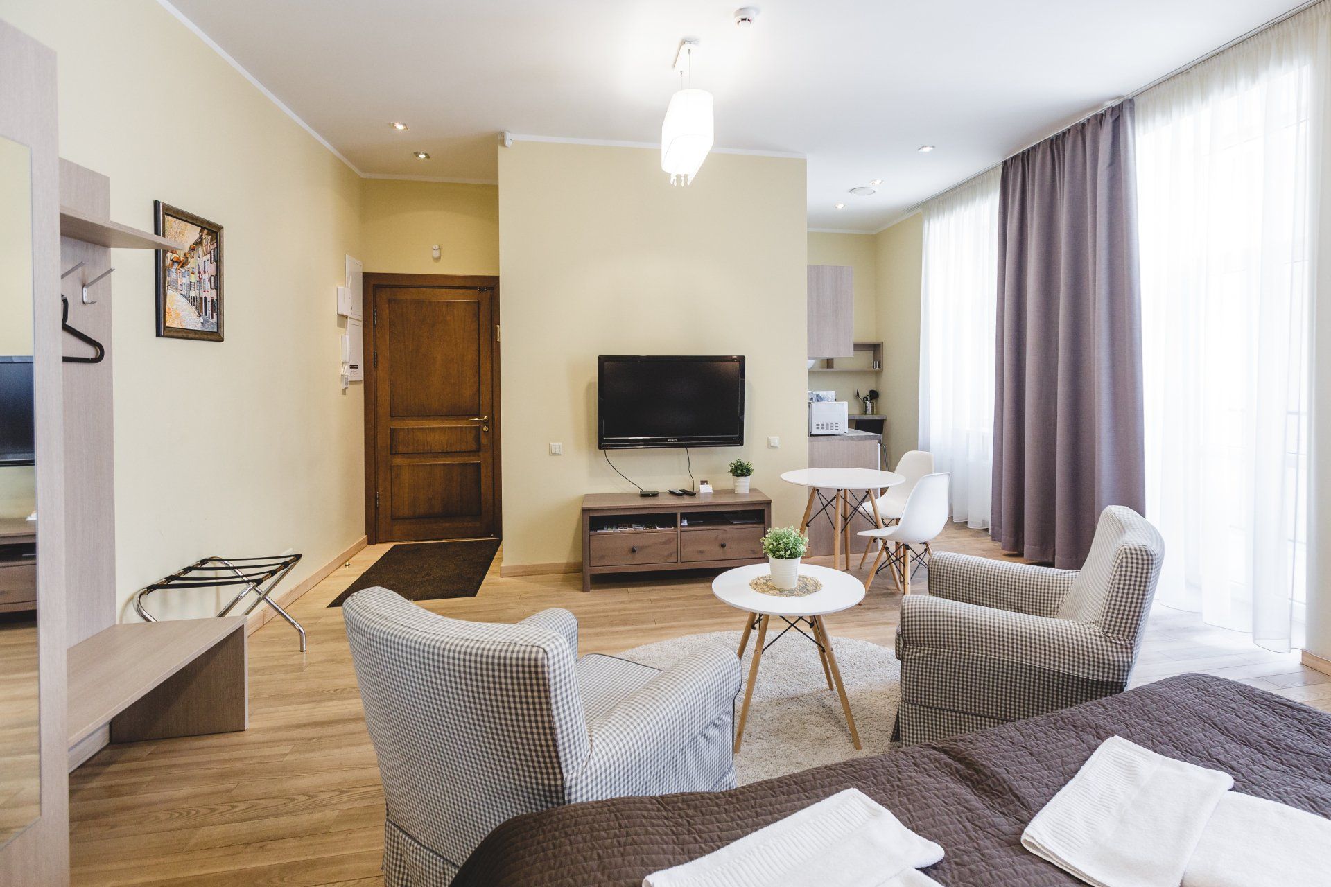 A living room with a bed , chairs , table and television.