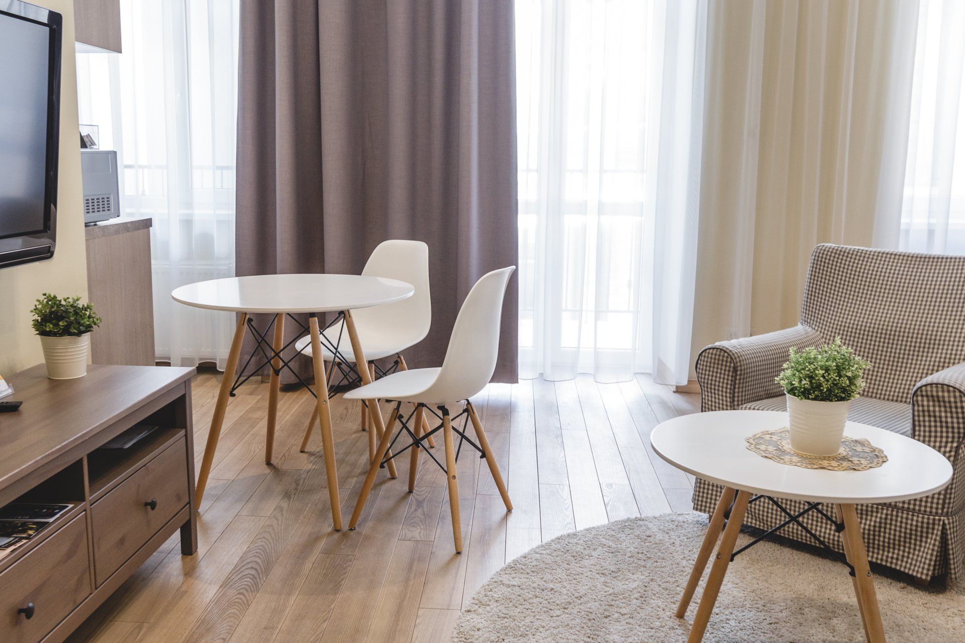 A living room with a couch , table , chairs and a television.