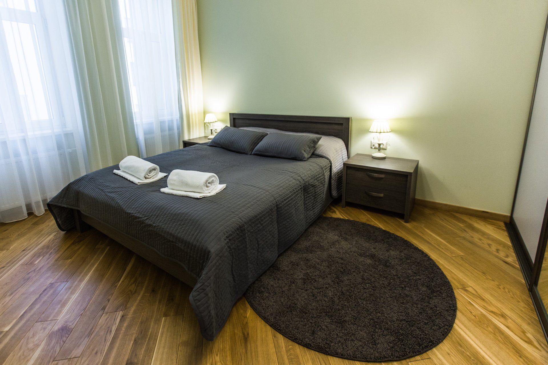 A bedroom with a bed , nightstand , and rug.