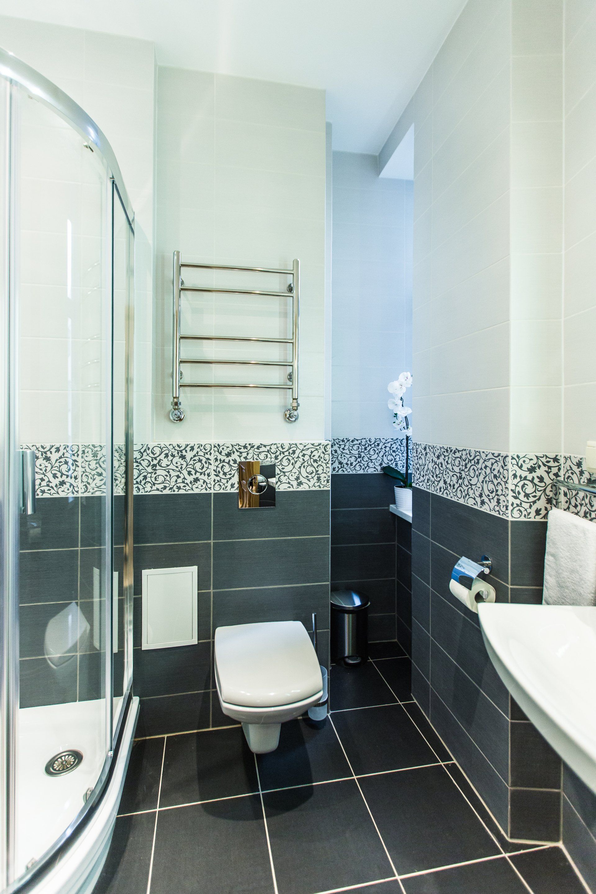 A bathroom with a toilet , sink and shower stall