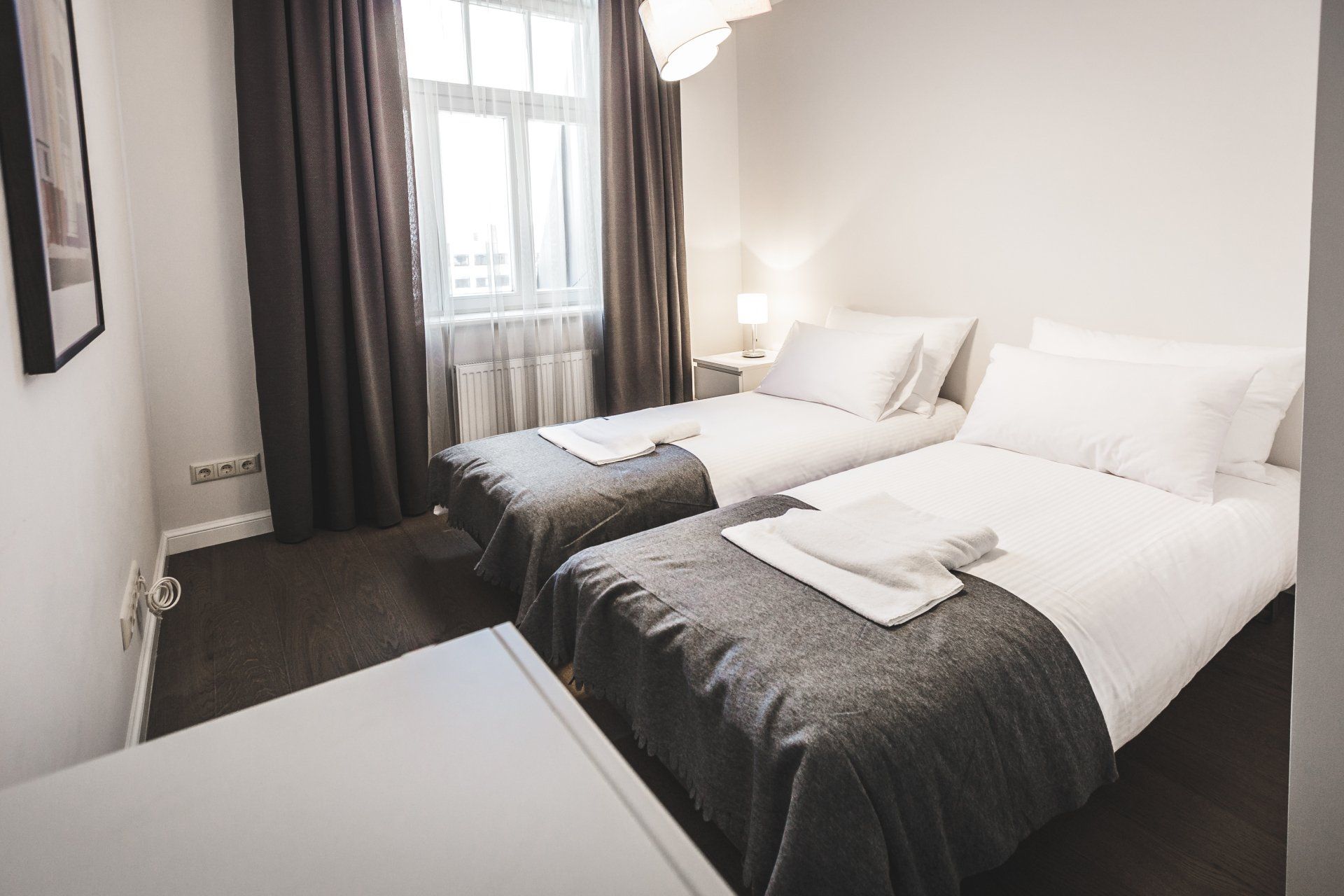 A hotel room with two beds and a window.