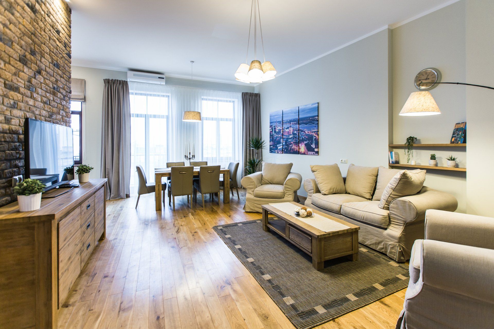 A living room with a couch , chairs , a table and a television.