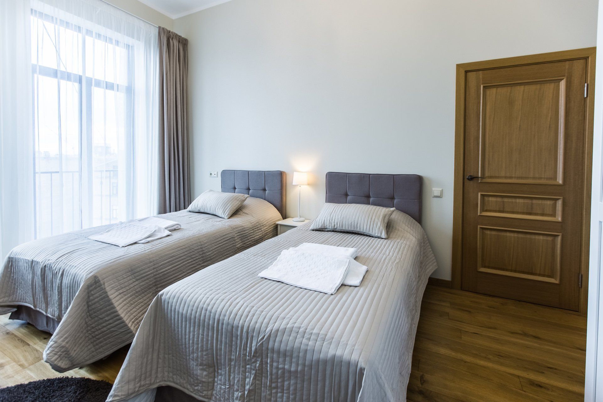 A bedroom with two twin beds and a wooden floor.