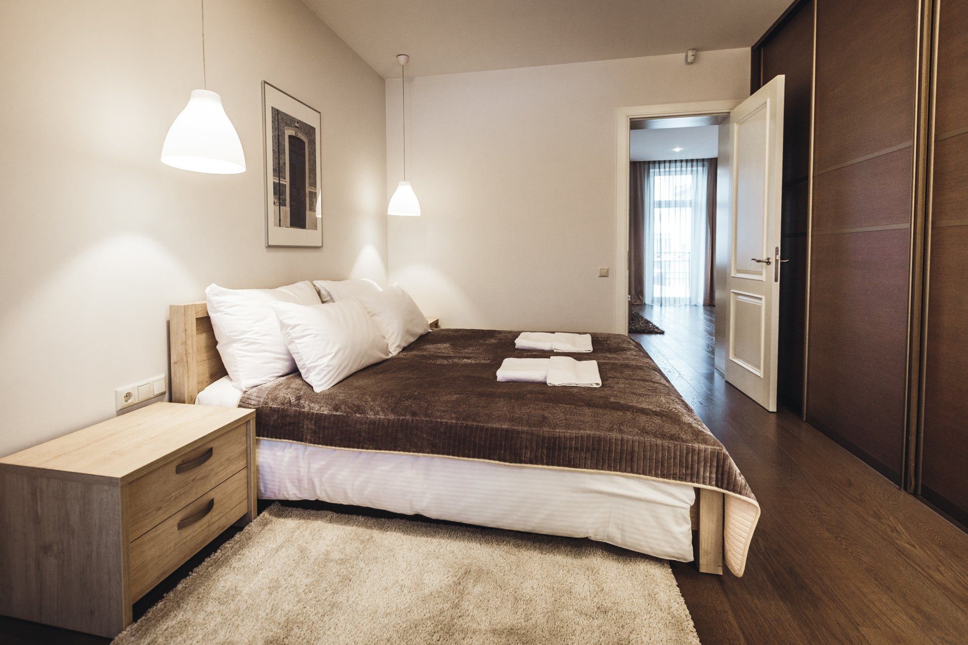 A bedroom with a large bed , nightstand , and rug.