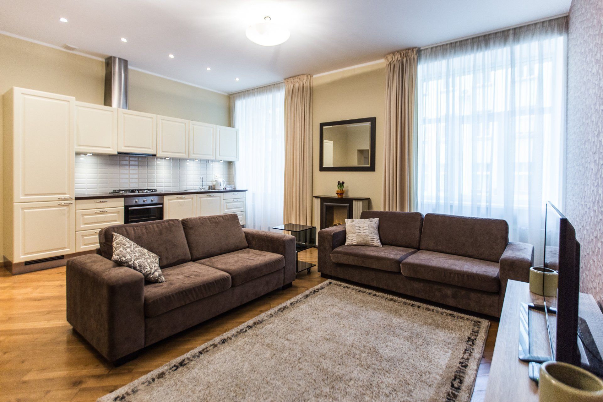 A living room with two couches , a rug and a television.