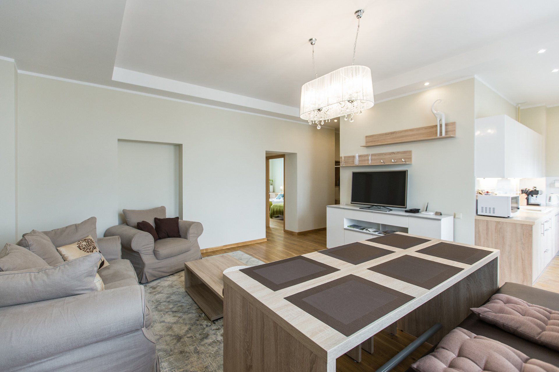 A living room with a couch , chair , table and television.