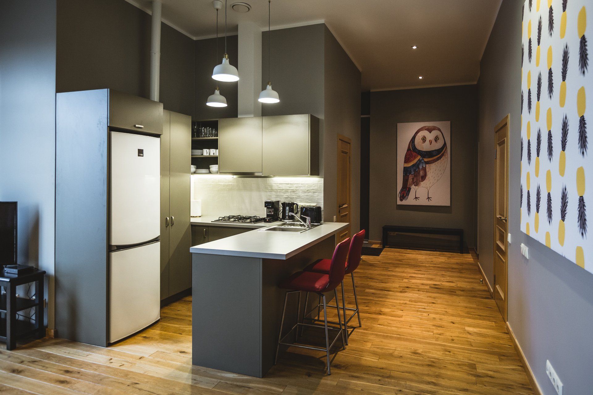 A kitchen with a large island and a painting of an owl on the wall.