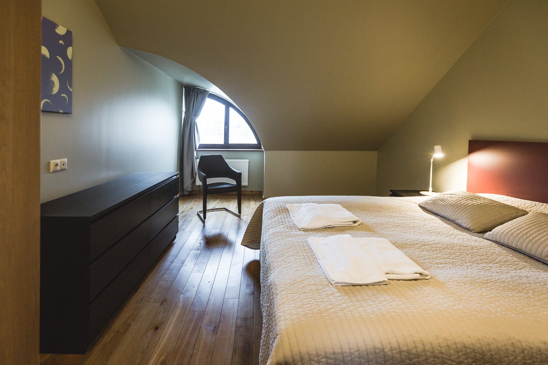 A bedroom with a bed and a chair in it