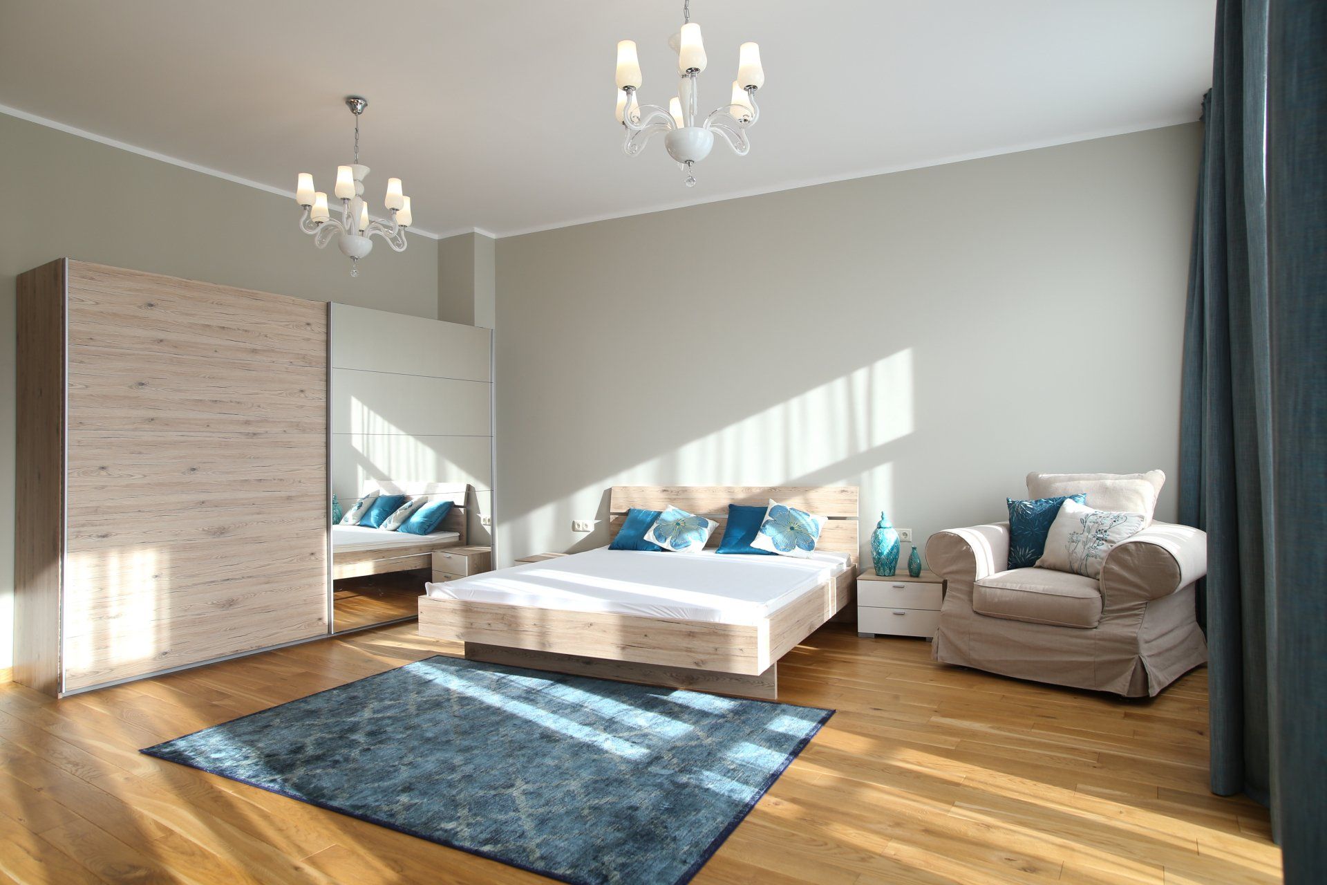 A bedroom with a bed , chair , rug and wardrobe.