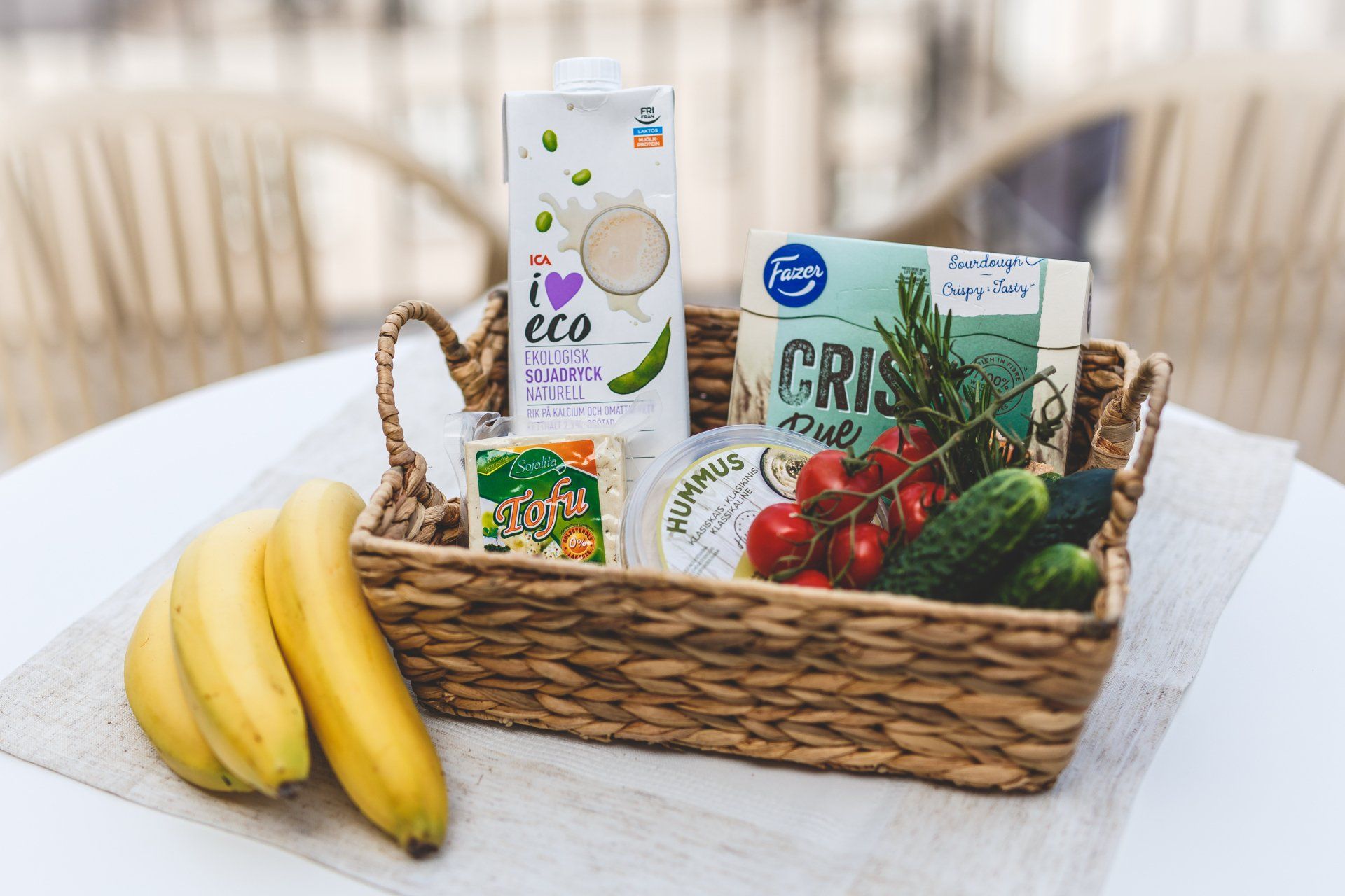 A basket filled with fruits and vegetables is on a table.