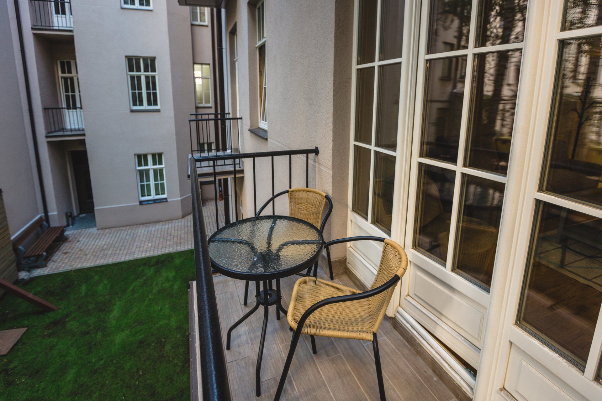 A balcony with a table and chairs in front of a building.