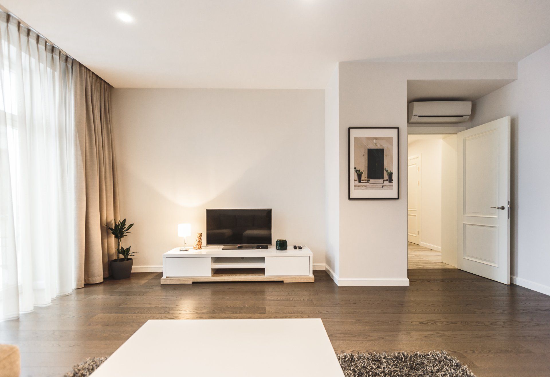 A living room with a flat screen tv on a stand.