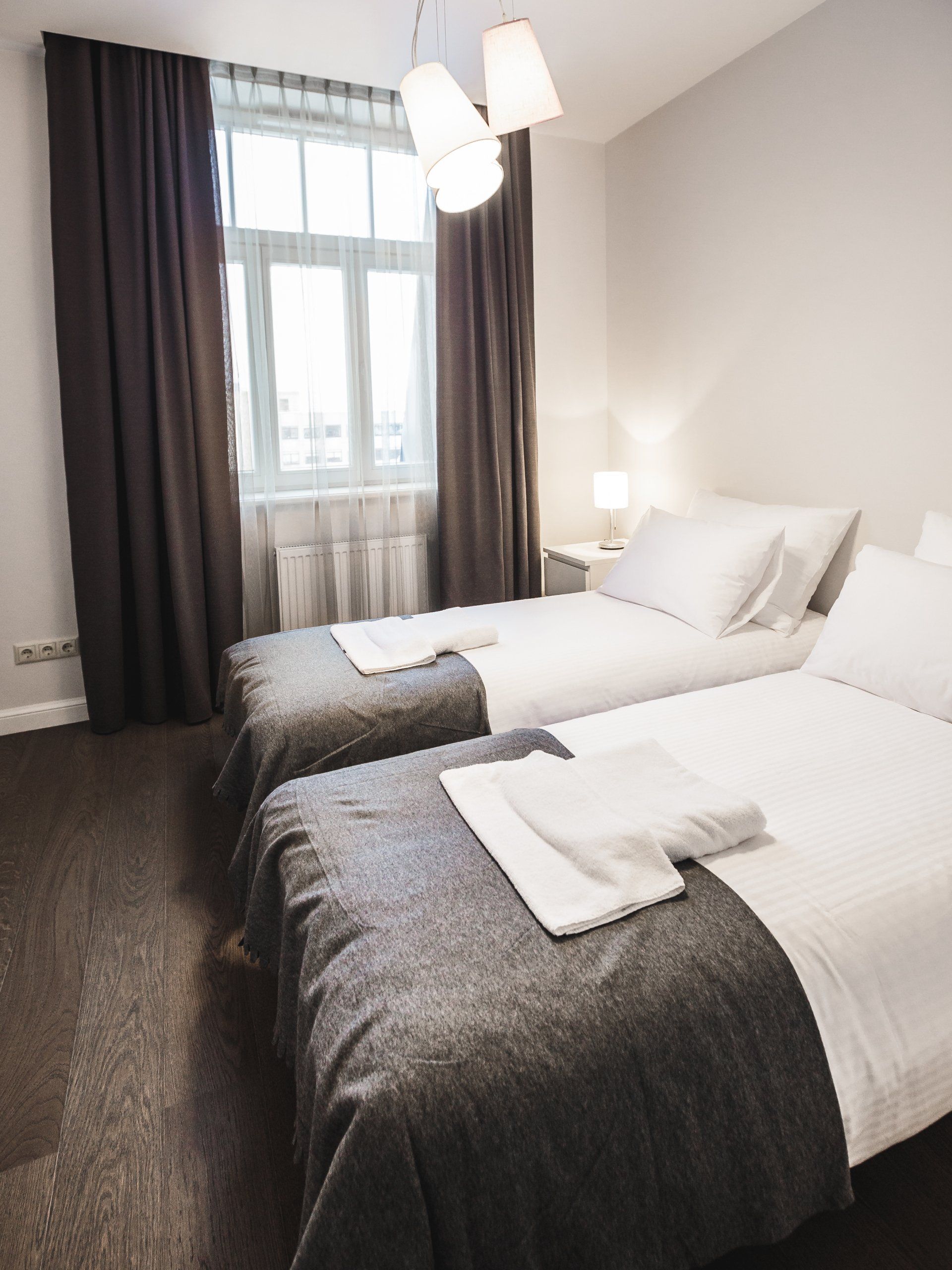 A hotel room with two beds and a window