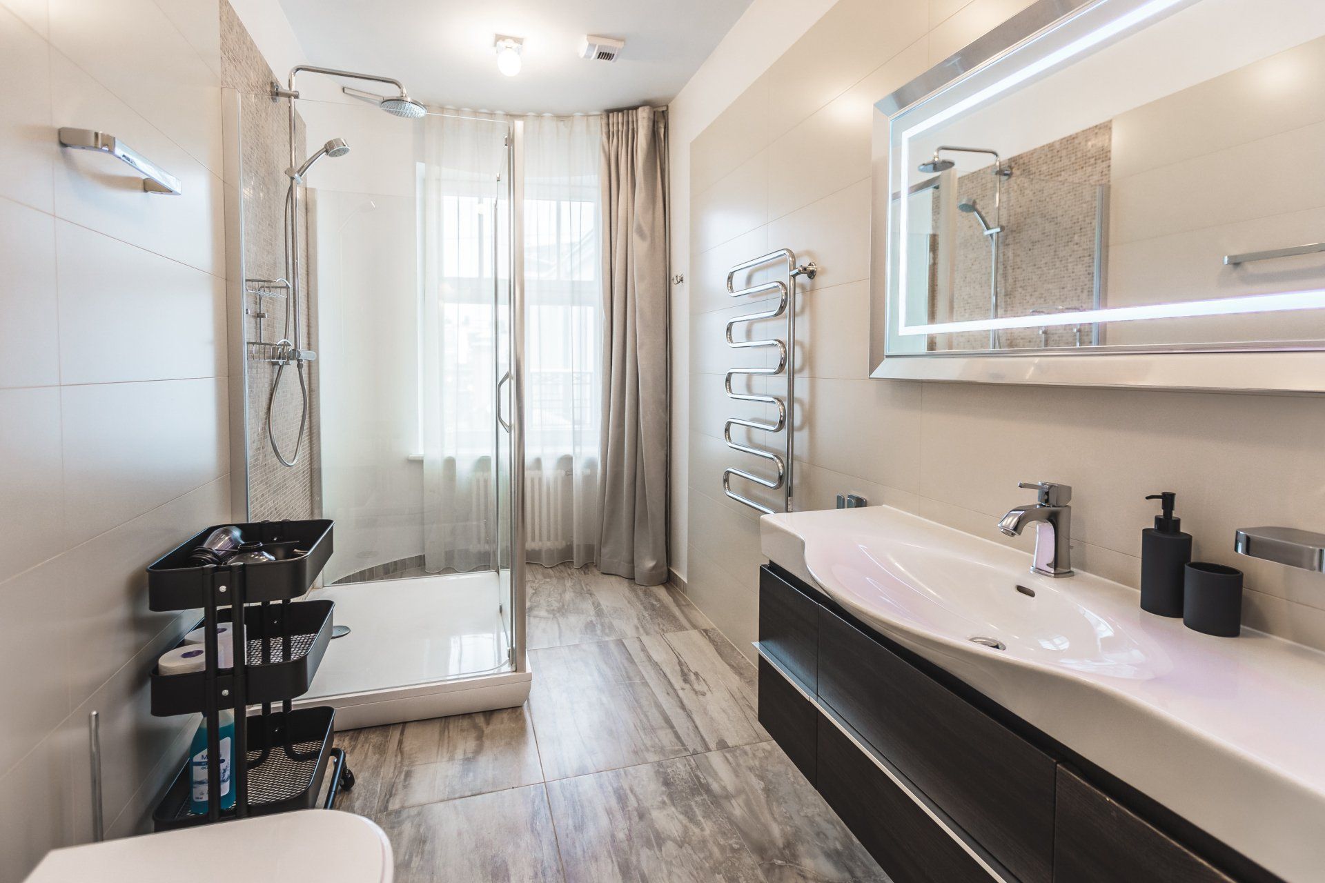 A bathroom with a sink , toilet , shower and mirror.