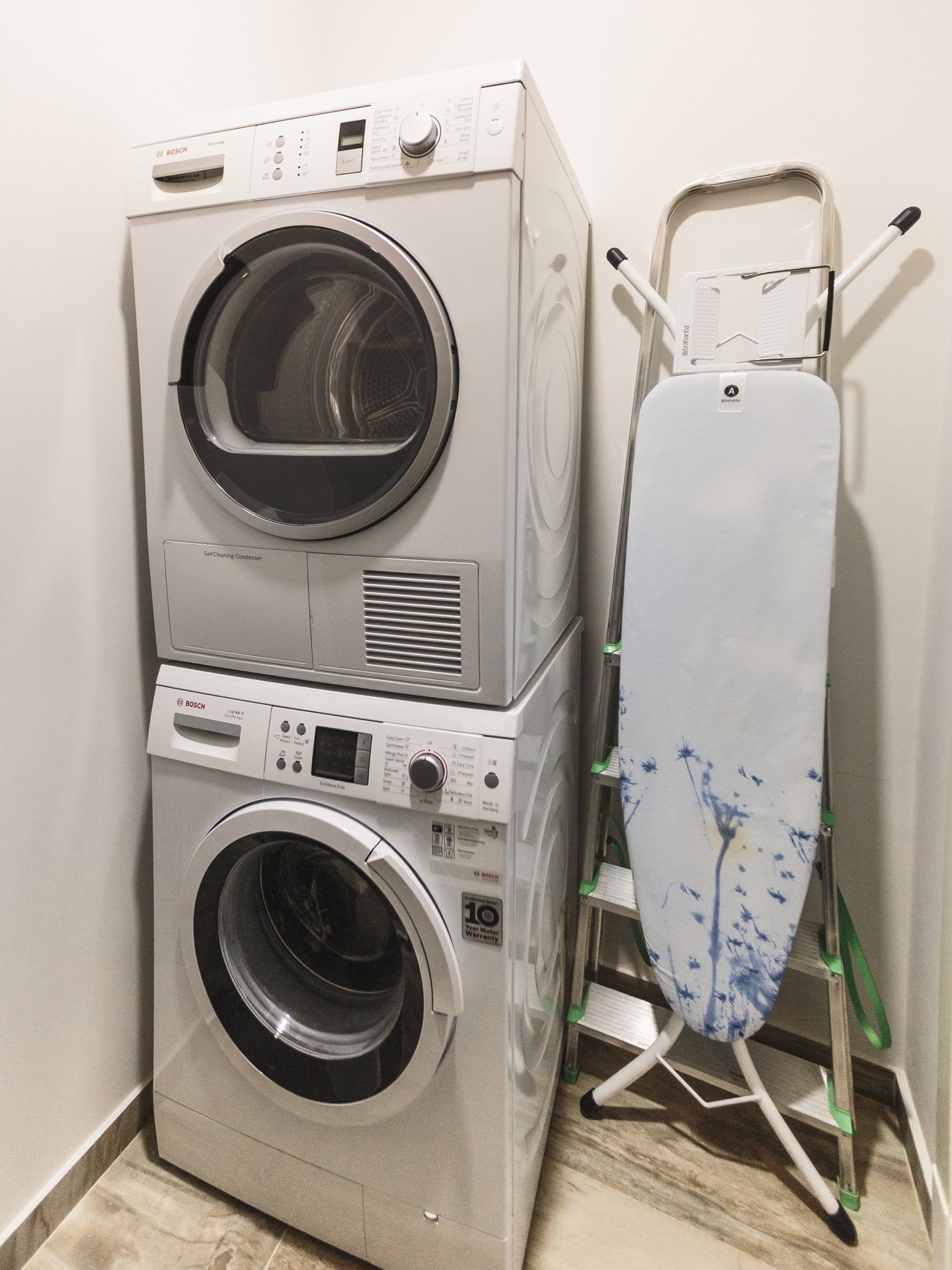 A washer and dryer are stacked on top of each other in a laundry room.