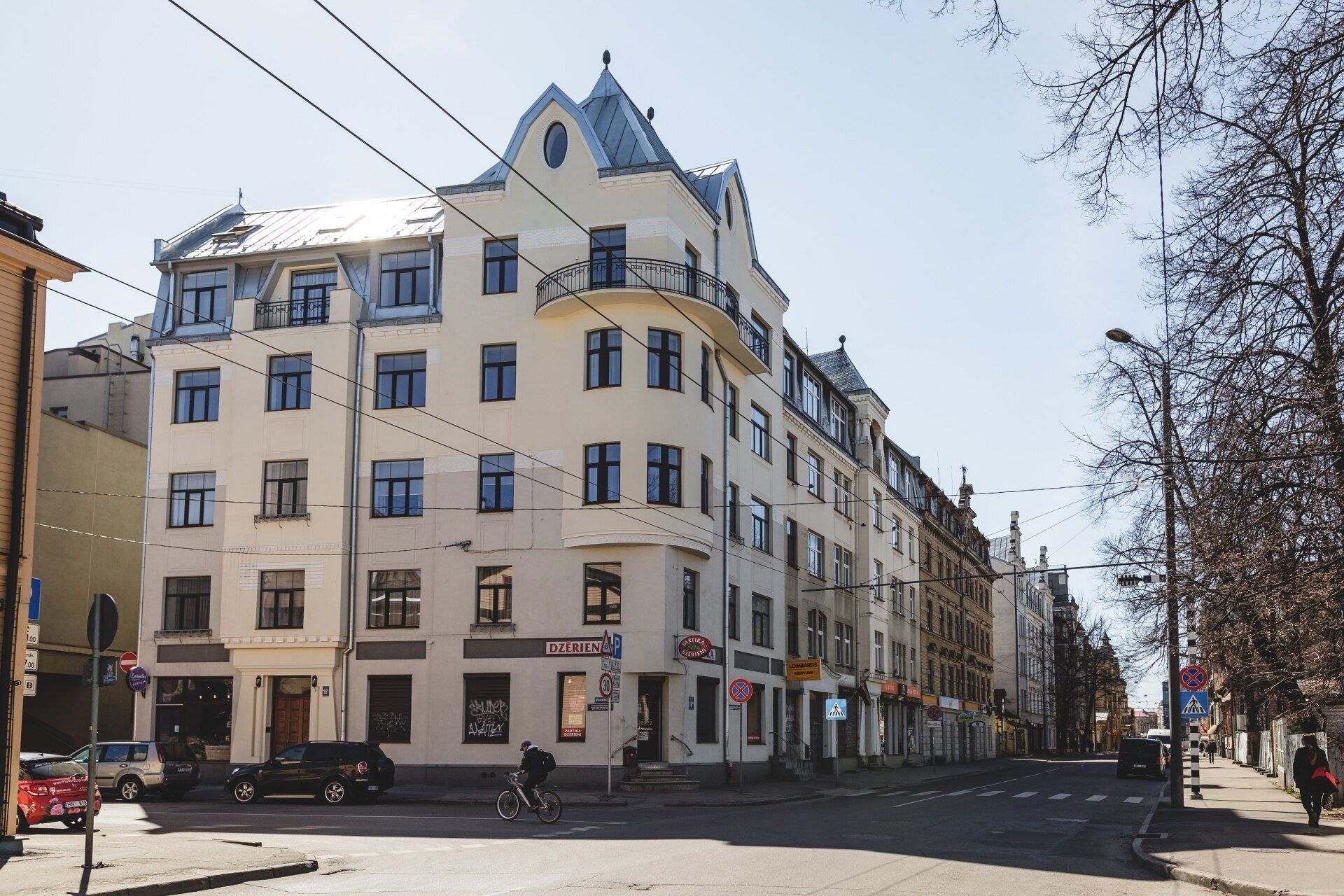 A city street with a large white building in the middle