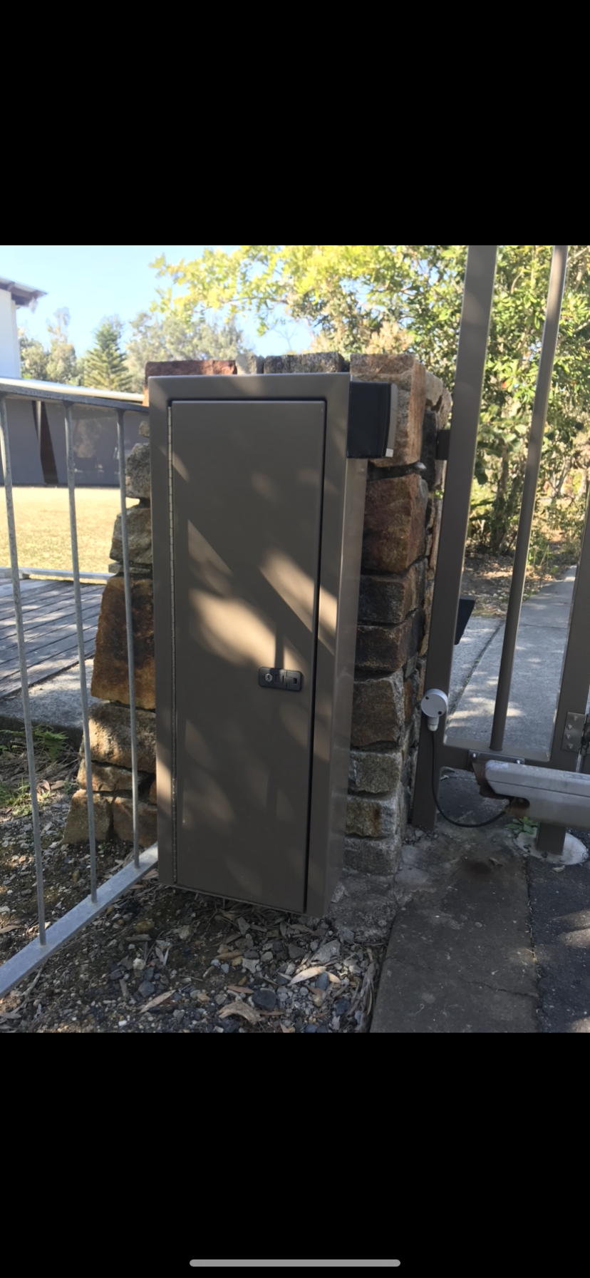 A wooden door is sitting next to a stone wall — Fabricator In Coffs Harbour, NSW